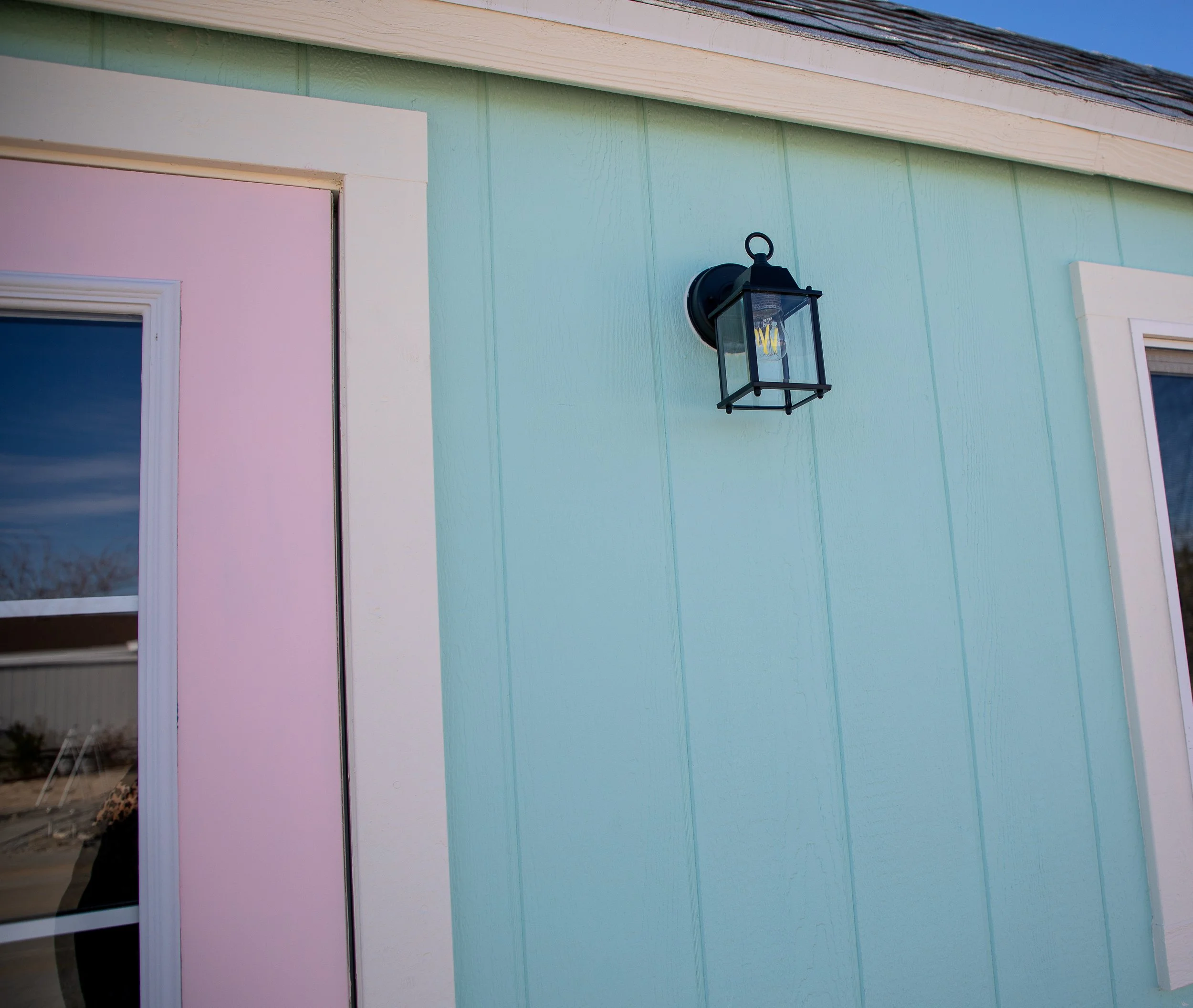 Cottagecore she shed with a black porch light for contrast.