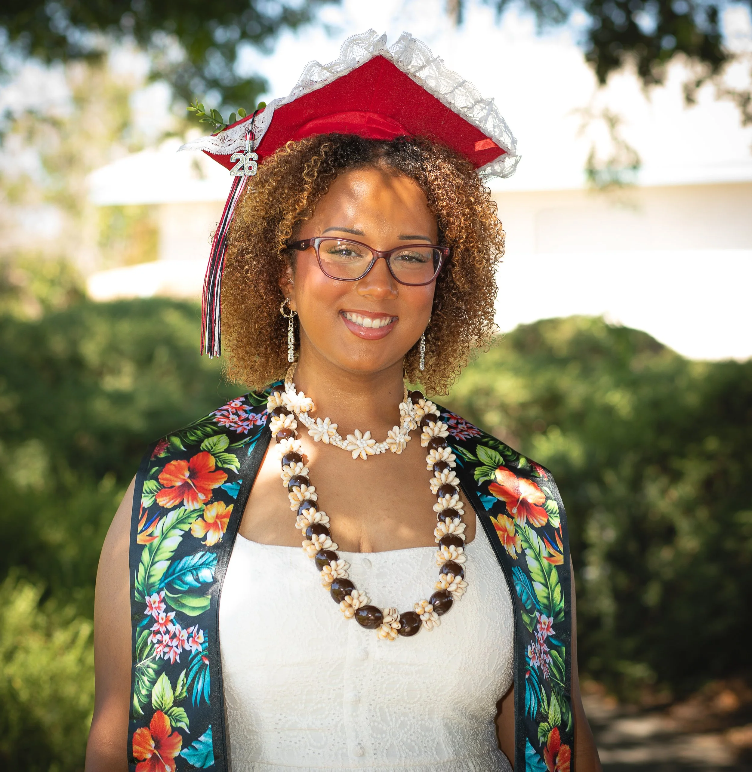 High school graduate wearing hawaiian heritage necklace and cap. 