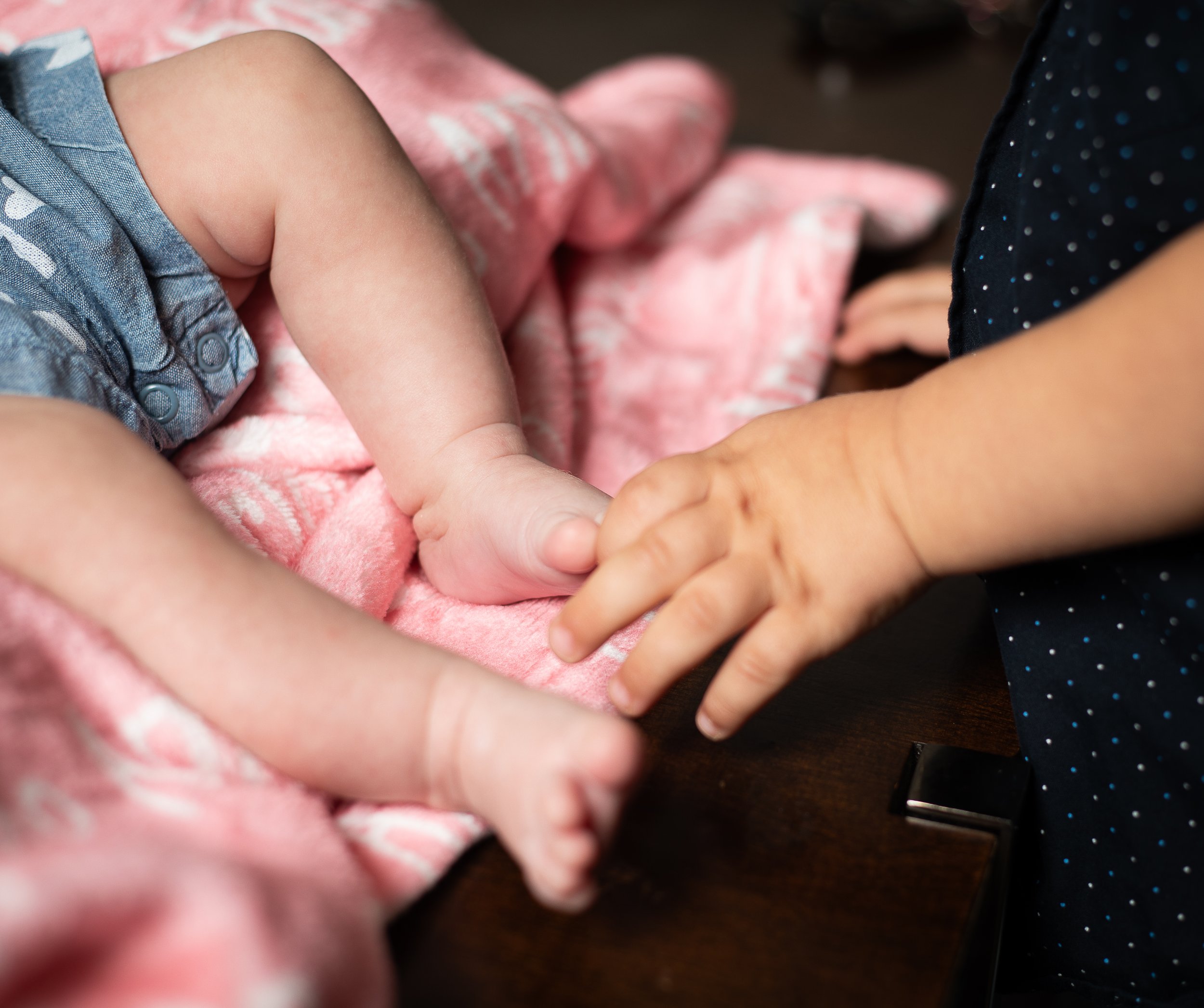 In home newborn photos of baby girl with sibling, in home high desert family photographer.