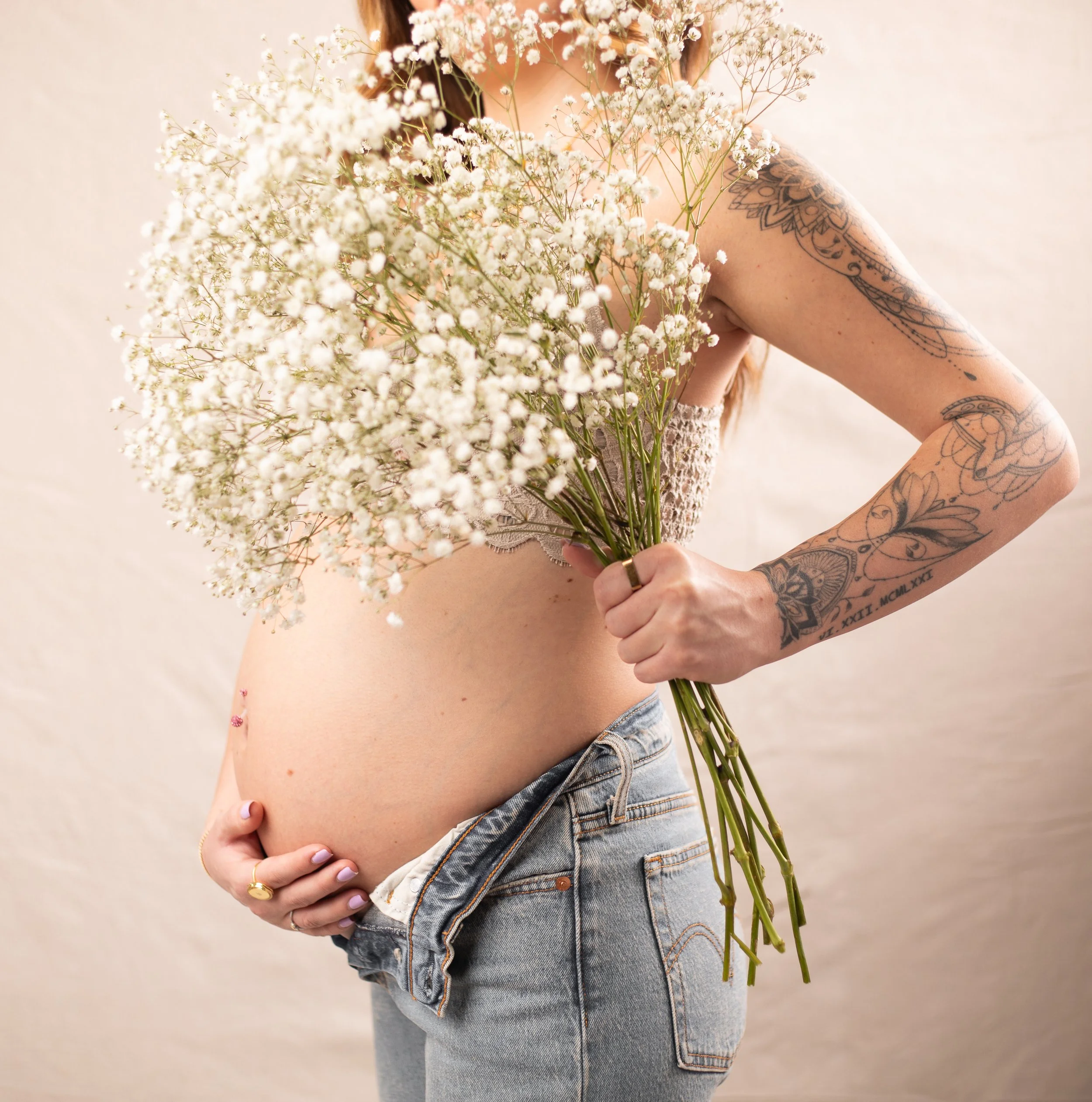 creative maternity portraits of belly and woman holding flowers by High desert HD family photographer