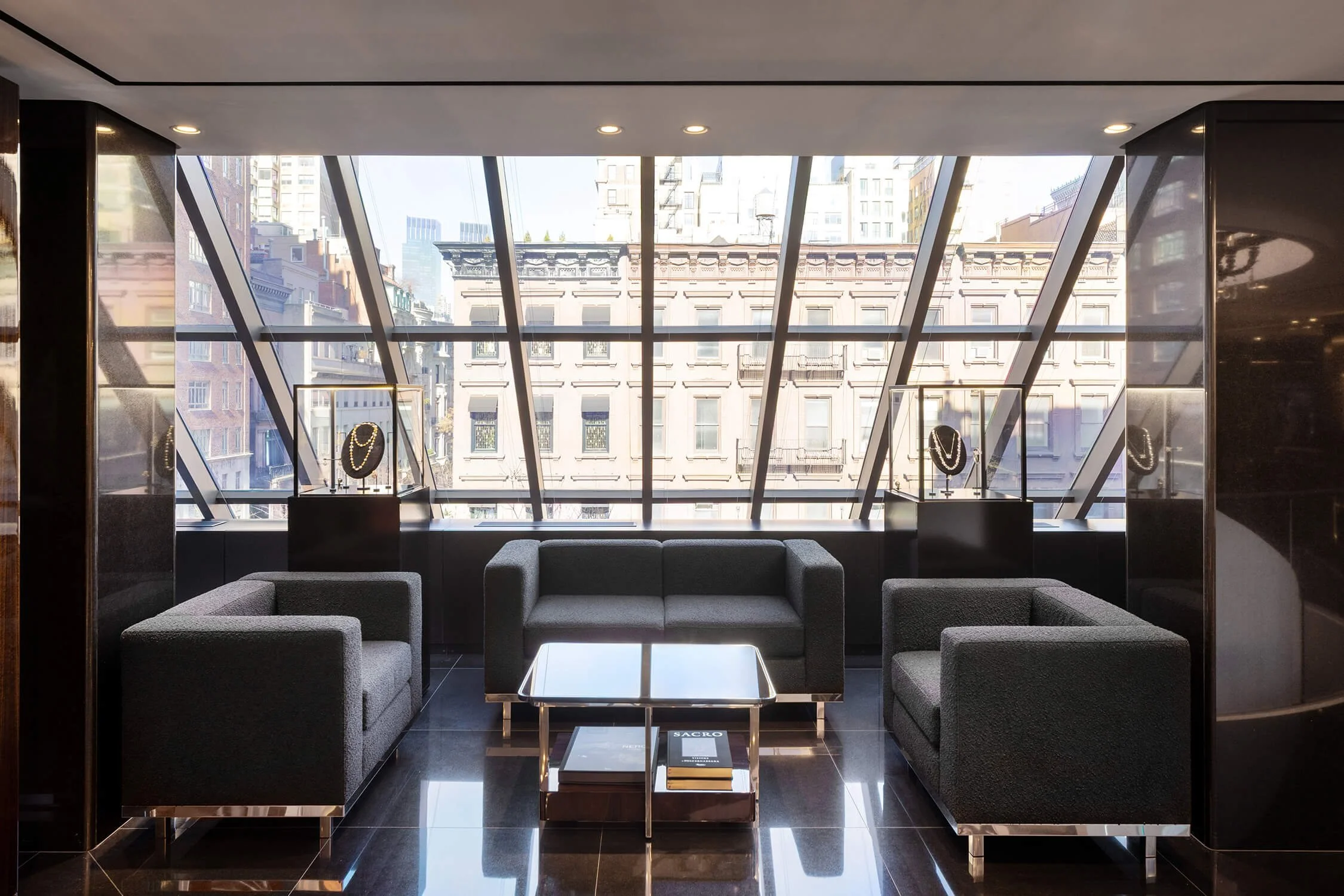 Lounge seating area with large windows and jewelry displays in Dolce & Gabbana store

