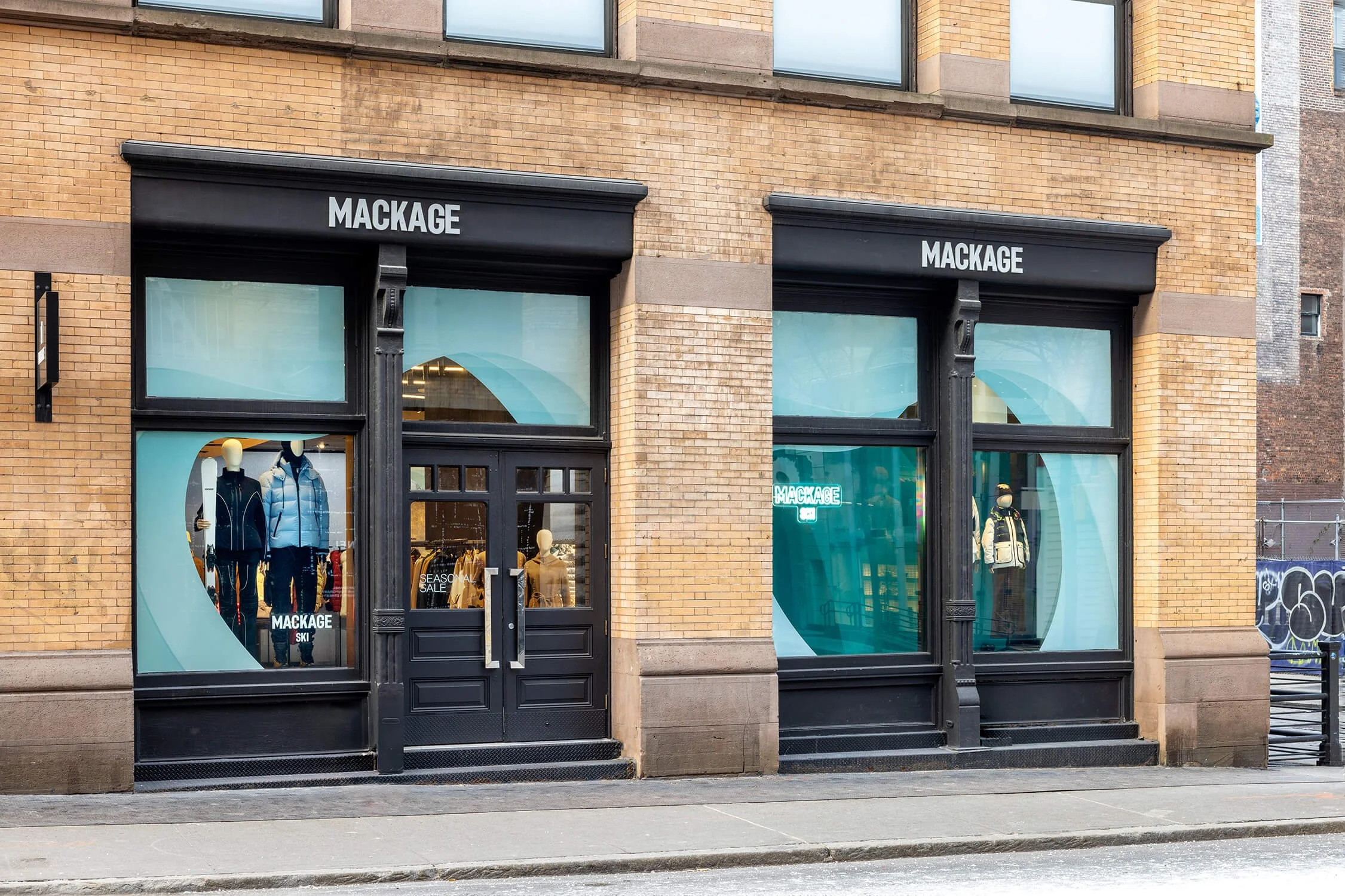 Fashion retail store exterior featuring coordinated winter mannequins and seasonal sale signage.