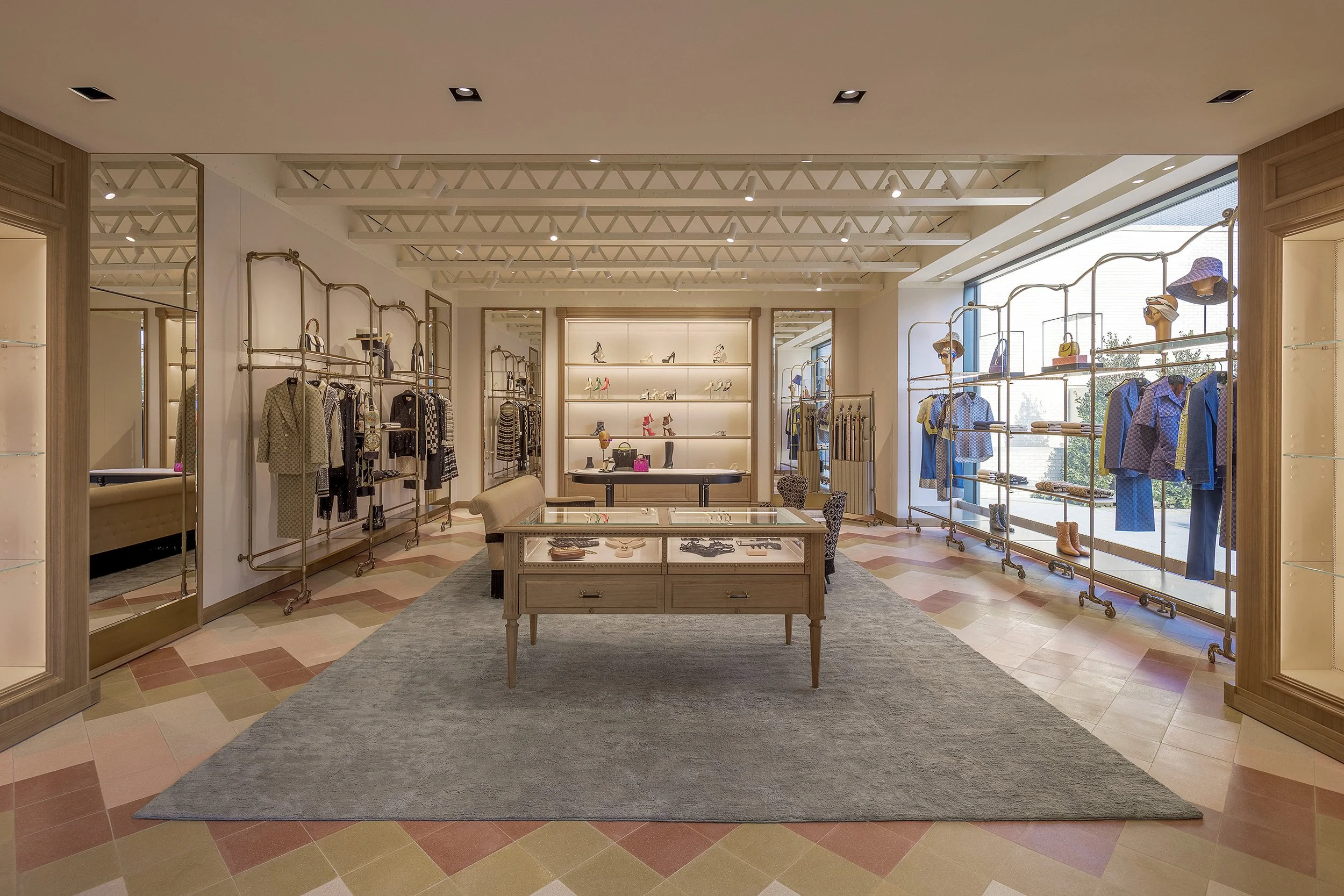 Spacious Gucci store interior featuring elegant displays of fashion items, shoes, and accessories with a colorful tiled floor.