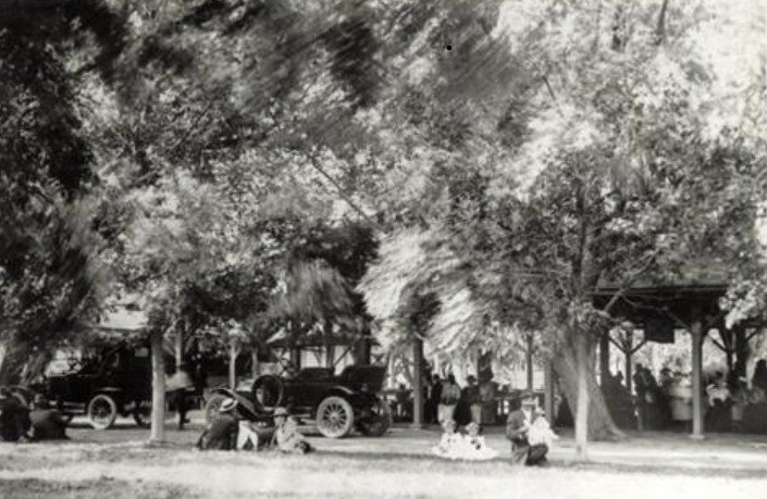 A black and white photograph of Saratoga Resort with automobiles and people in both the back and foreground. Photo courtesy of Mick Eastmond. Date unknown.
