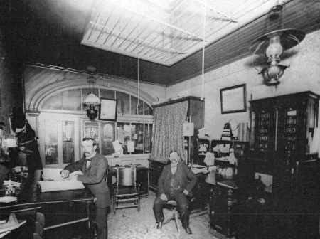 William Racker (right) in his office at the People’s Co-op, circa 1895. Racker managed both stores before leaving on a mission in 1899. FamilySearch.com.