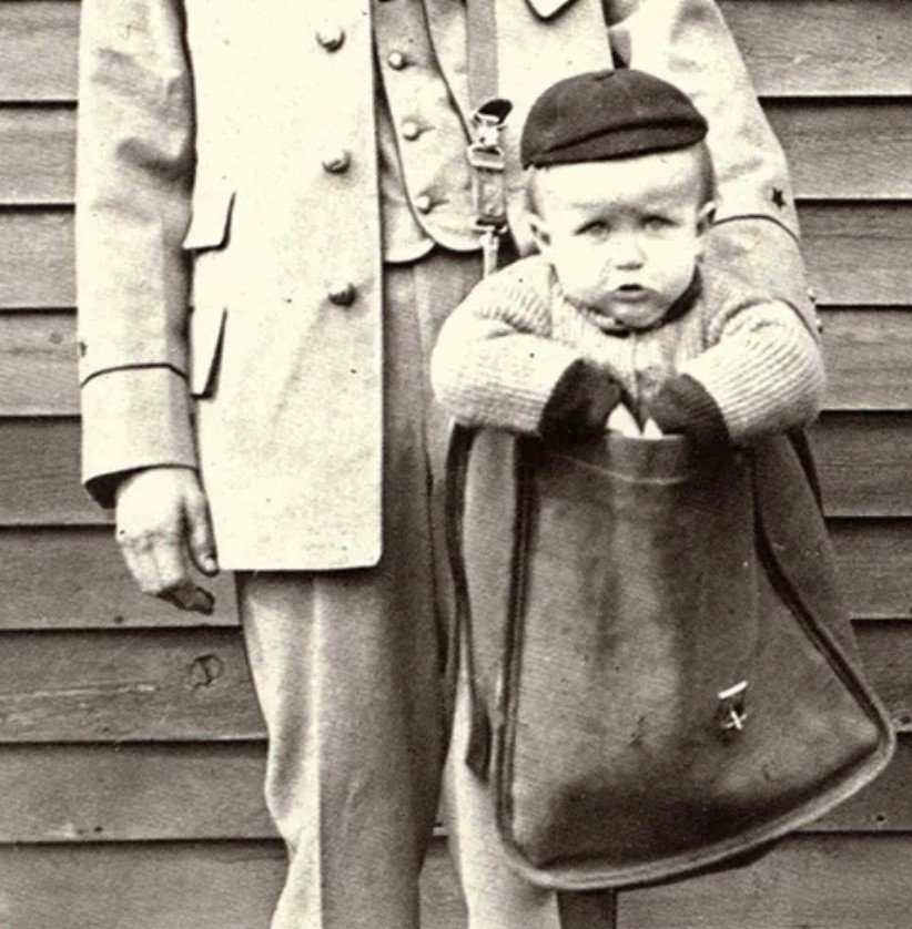 Uniformed Letter Carrier with Child in Mailbag. Courtesy of the Smithsonian Institution.