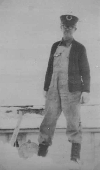 William standing on a snow bank nearly covering the mailbox, 1937.