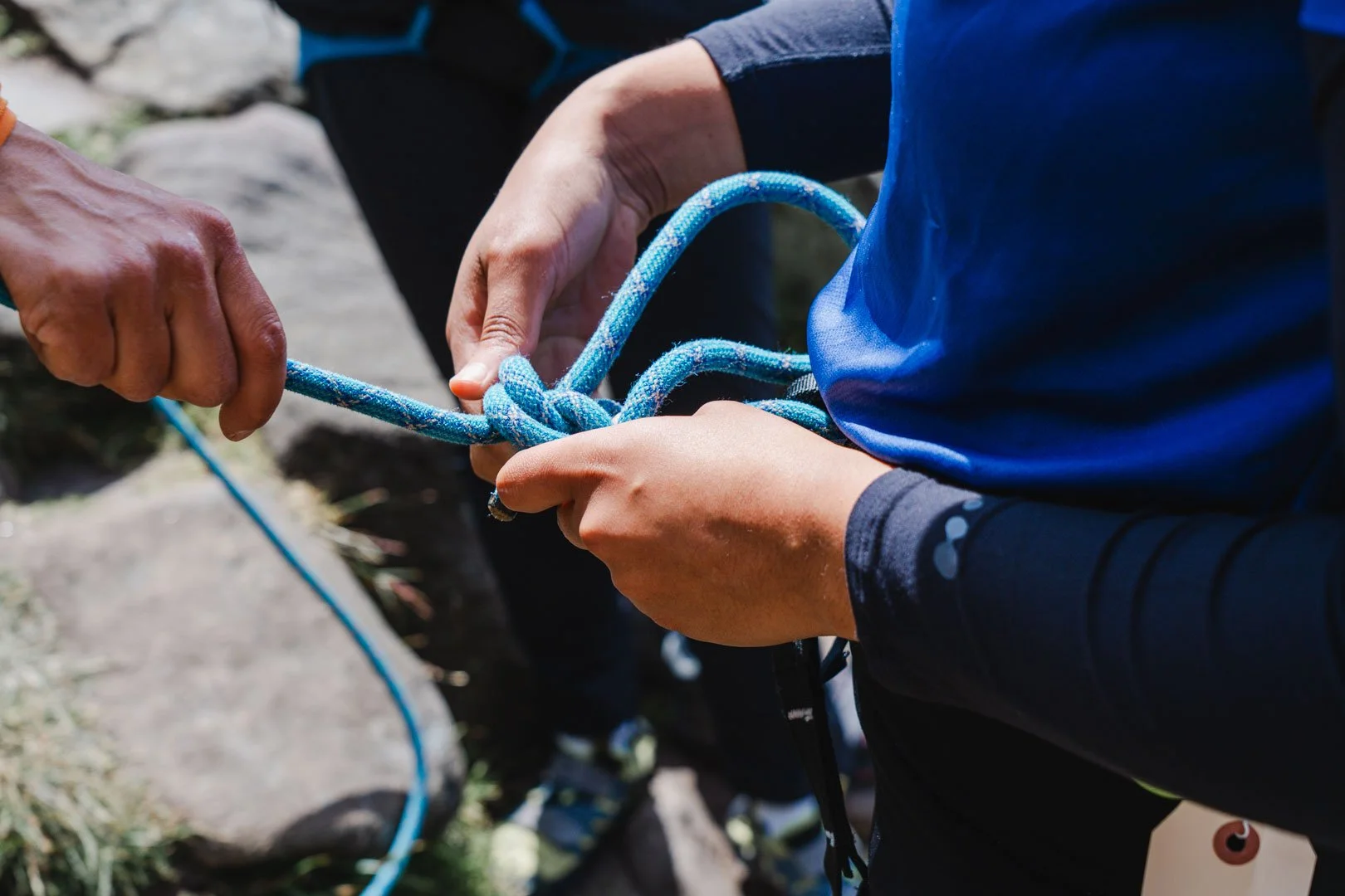 Someone tying a figure of 8 knot