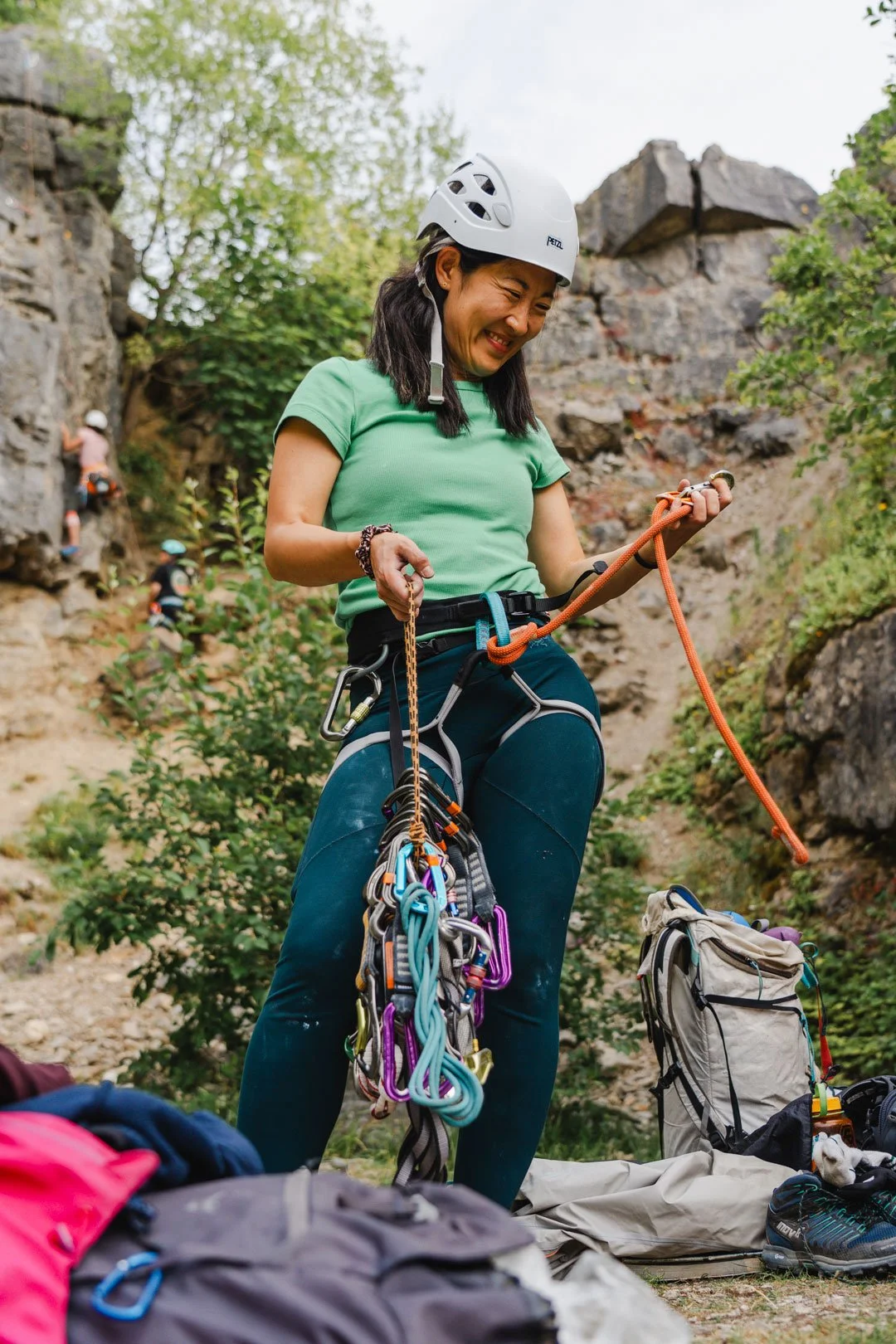 a climber smiles while sorting through their quickdraws