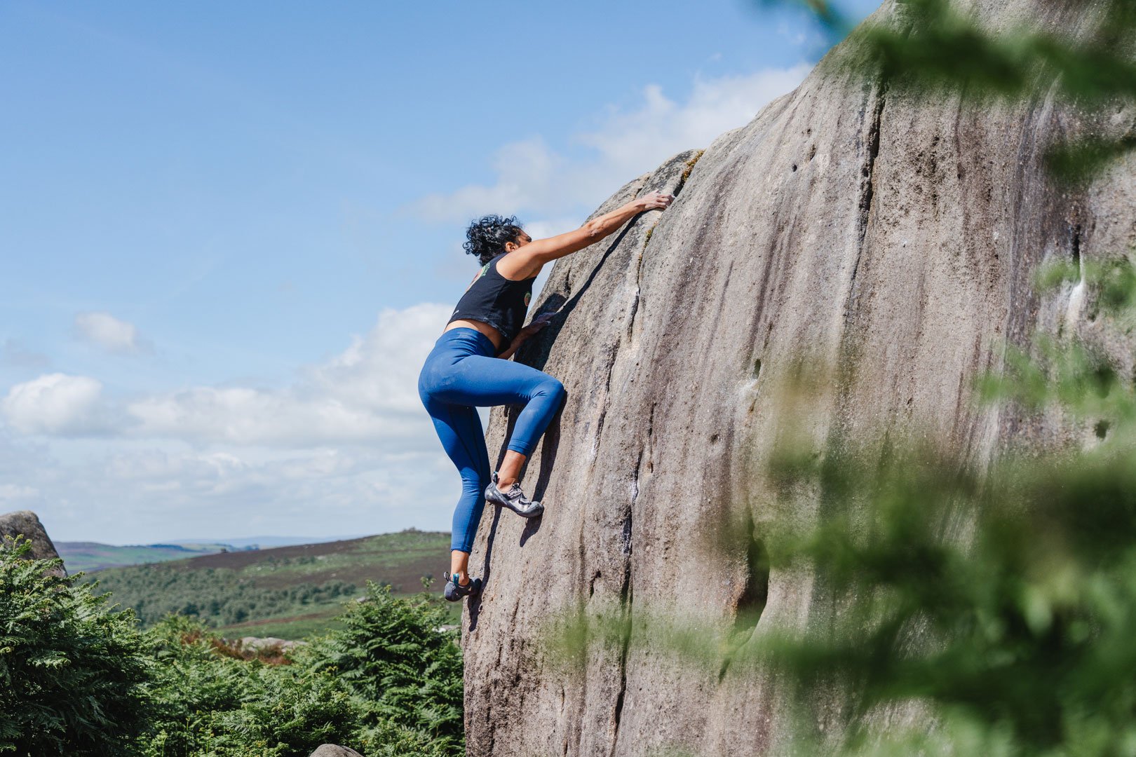 A climber ascends a boulder