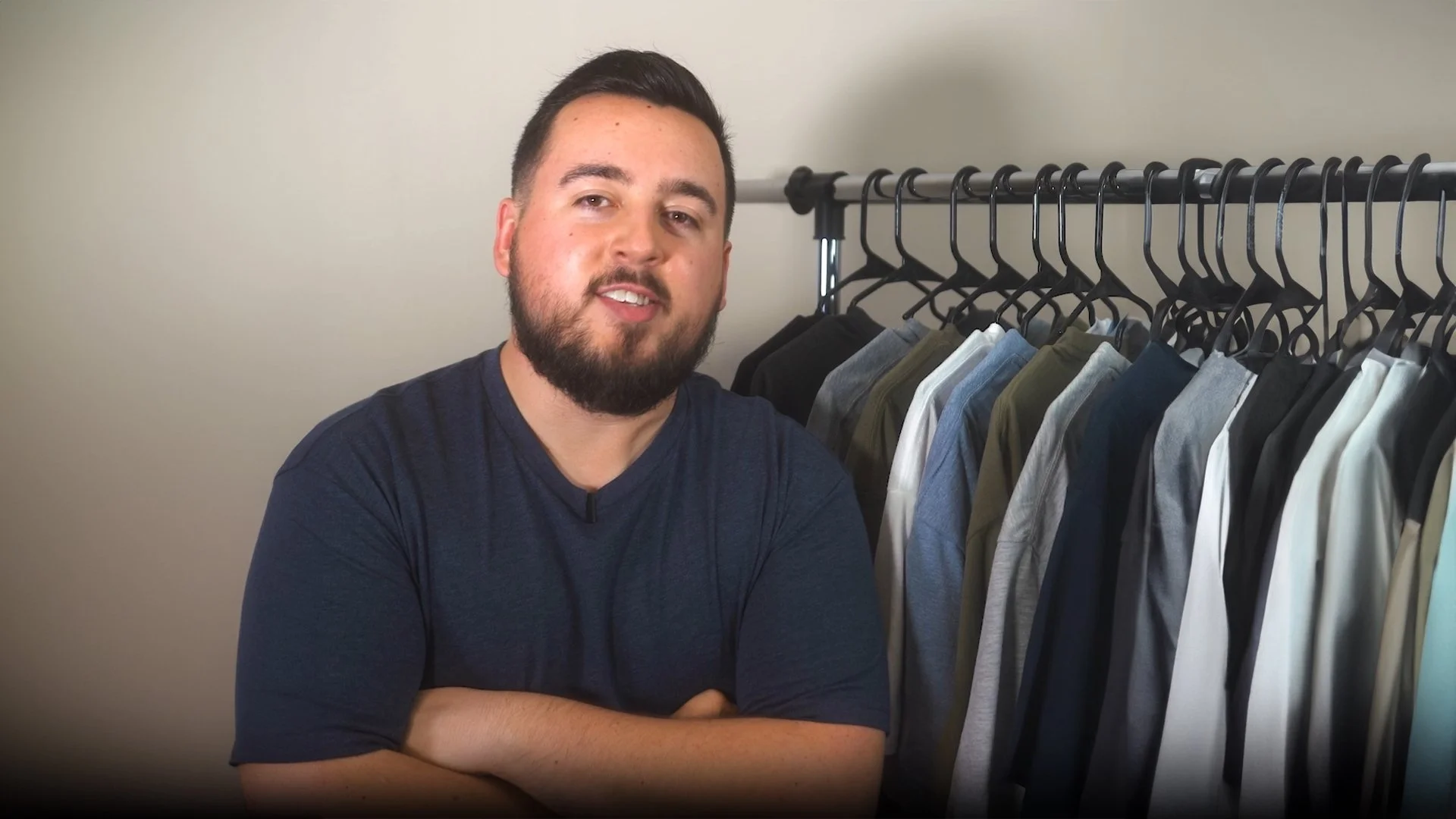 Matt Philie standing in front of a clothing rack filled with various colored T-shirts.
