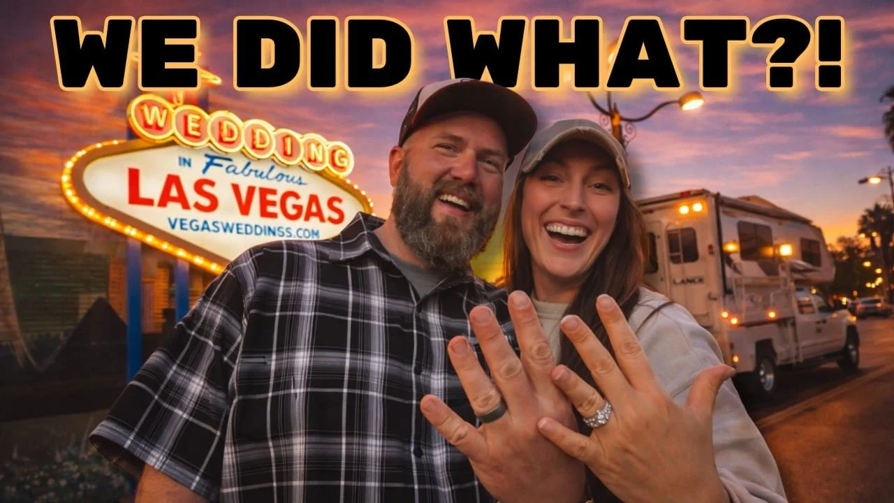 A couple happily showing off their wedding rings in front of the Las Vegas sign at sunset.