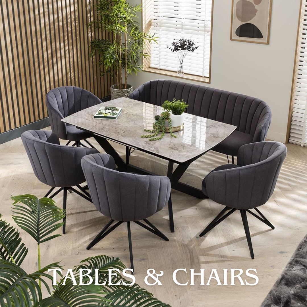 Modern dining area with gray chairs and a marble top table, surrounded by indoor plants and decor.
