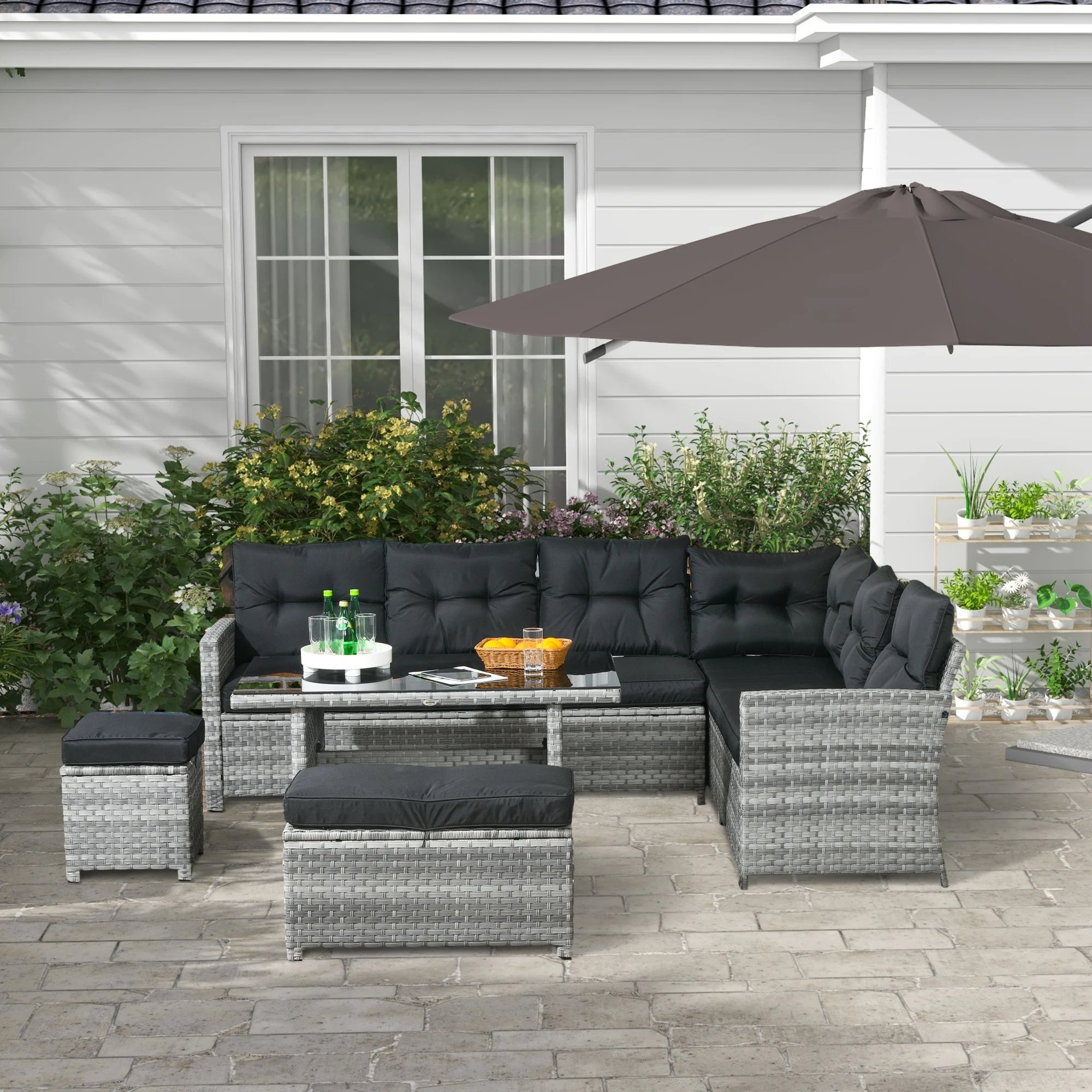 Modern grey rattan outdoor furniture set with coffee table and armchairs on tiled patio