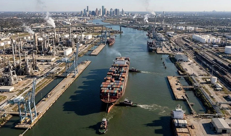 High-angle aerial view of the Houston Ship Channel featuring heavy industrial infrastructure, refineries, and a container ship, representing the core sectors served by The Precision Firm business brokerage in Houston, Texas.