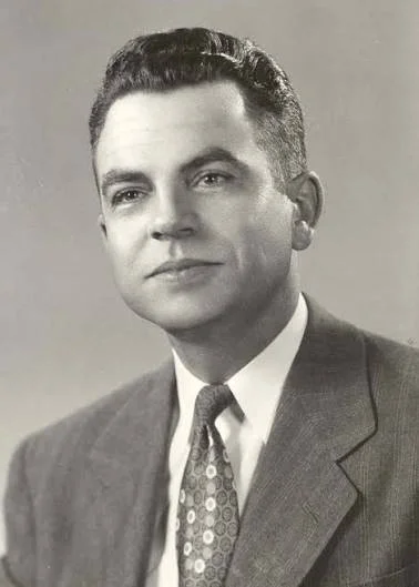 Photo of a man in suit and tie.