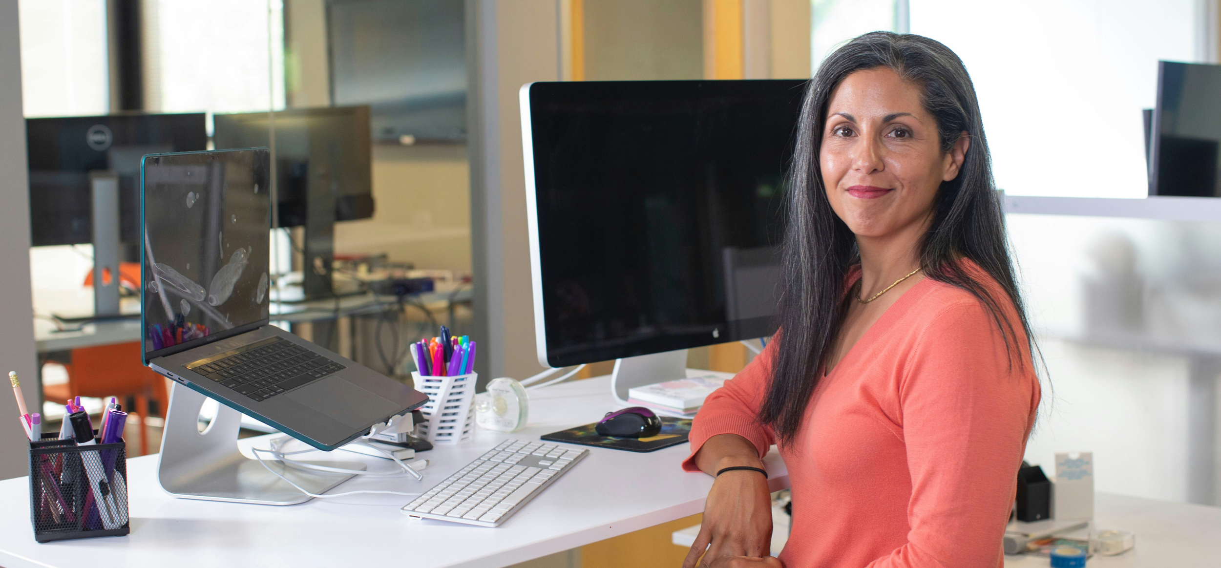 Woman in front of a laptop and desktop
