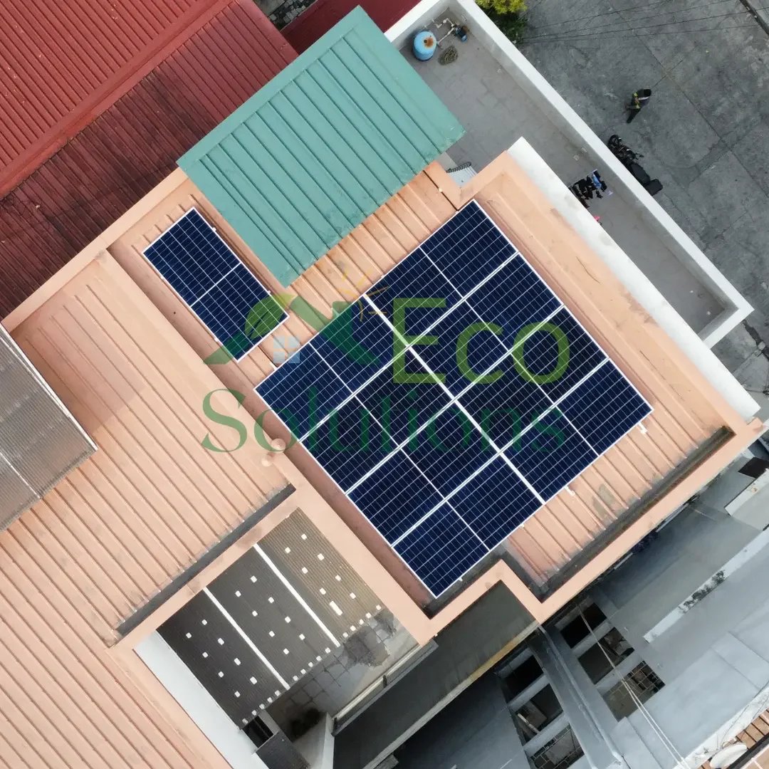 High-altitude drone shot looking down at the rooftop array, showing the clean, uniform look of the LONGi Back Contact panels against the roof geometry.