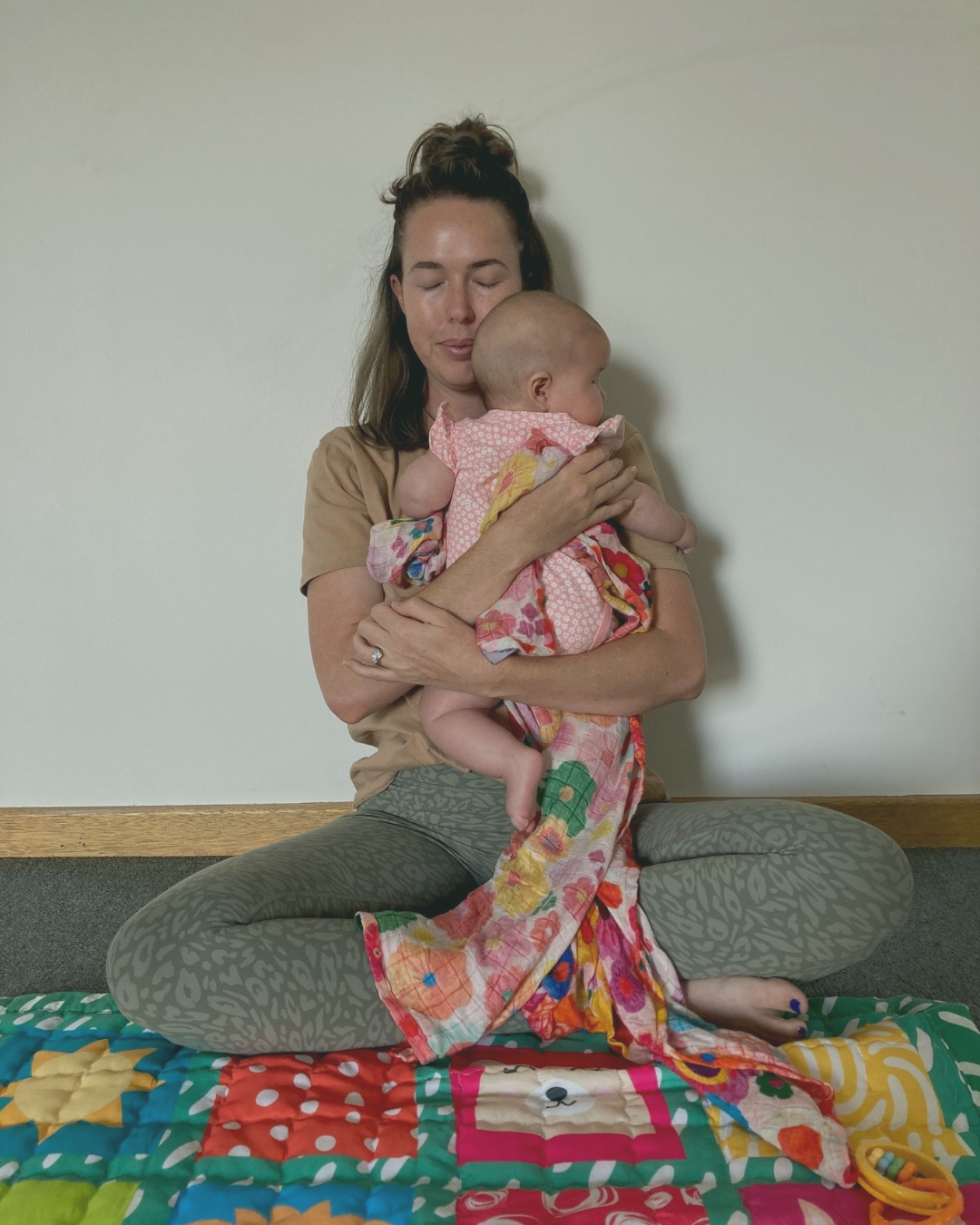 New mother lying on a hammock, cuddling her newborn baby