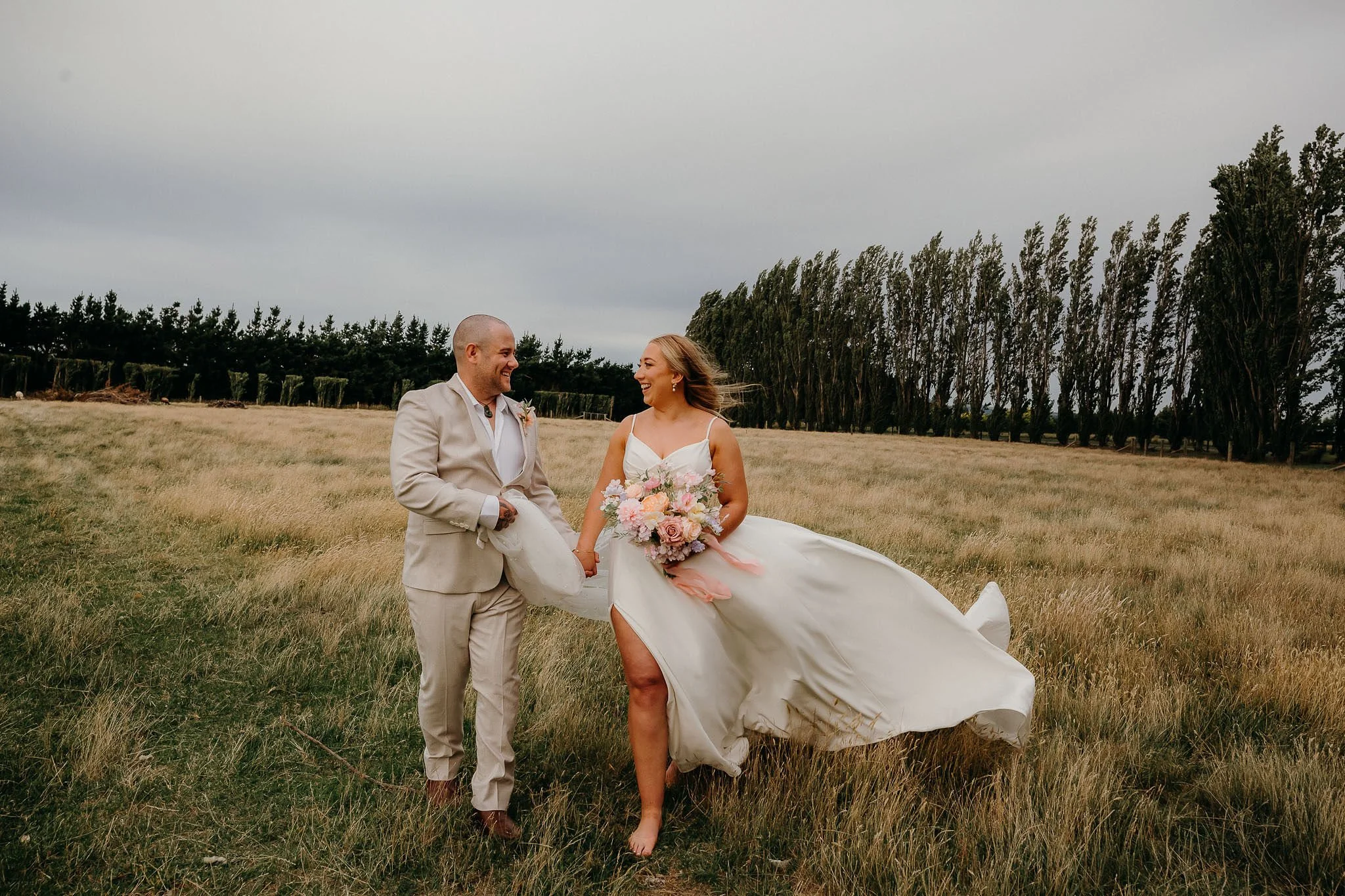 Bride and Groom walking together grom holding brides dress bride holding bouquet