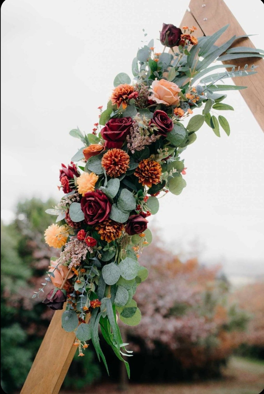wedding triangular arch with deep red florals