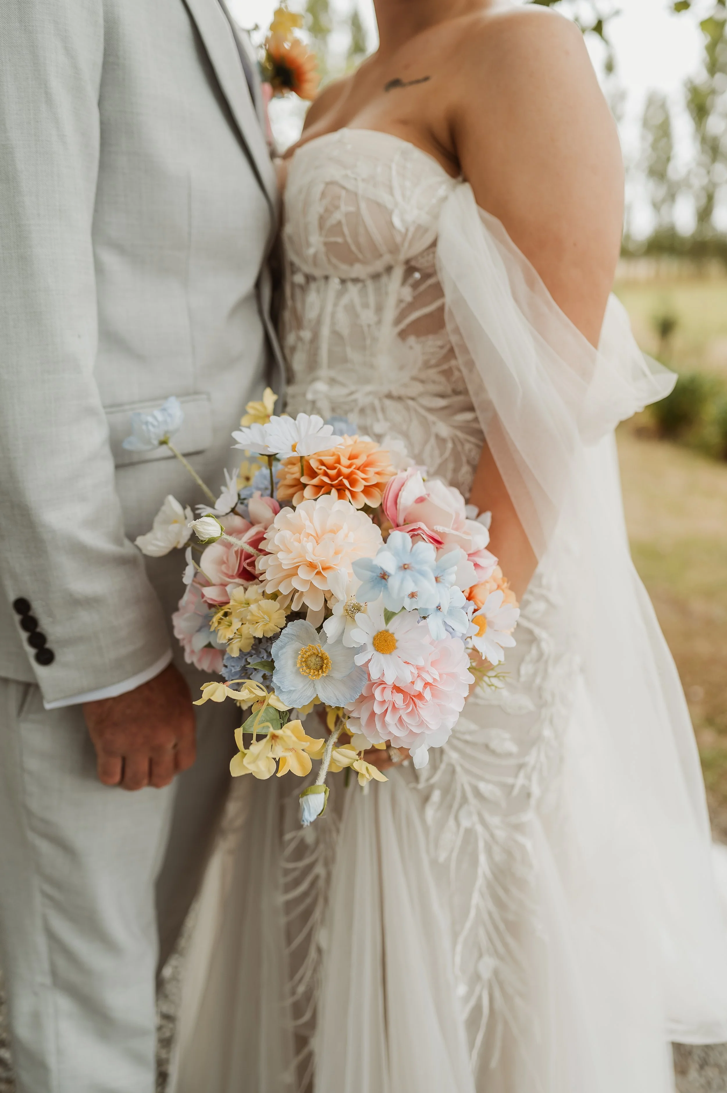 autumnal bouquet with yellow florals accompanying a beautiful tulle and lace gown