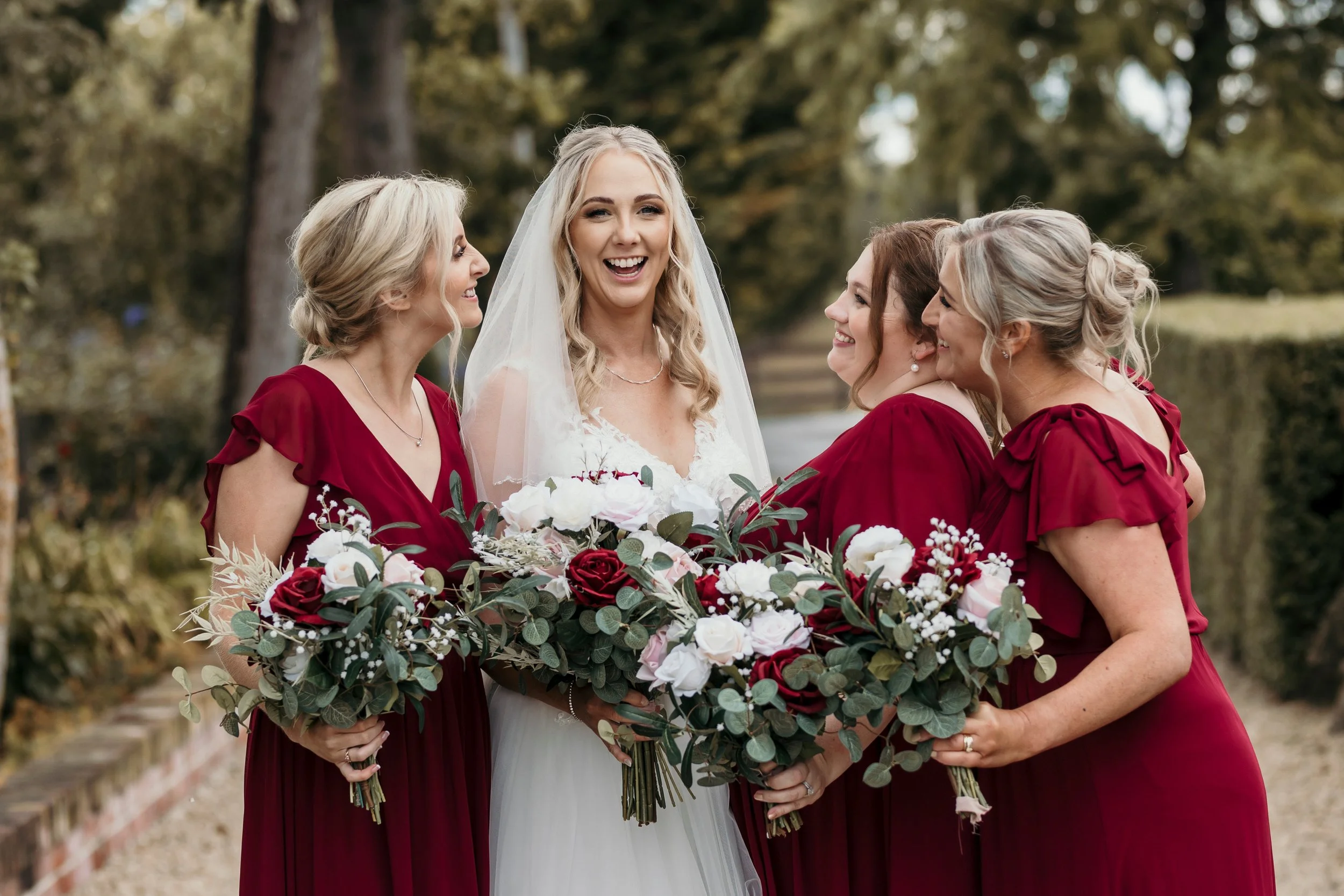 red, white and pink bride and bridesmaids bouquets during bridal party photos with the girls
