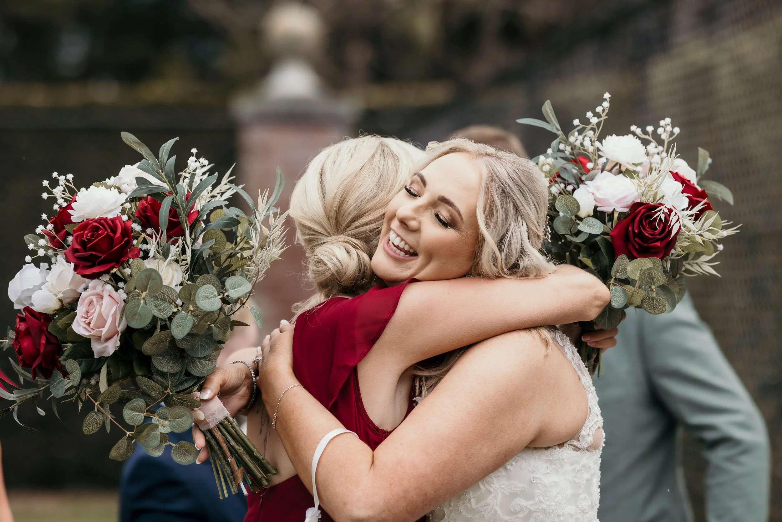red white and pink bouquet featured while guests congratulate the bride and groom