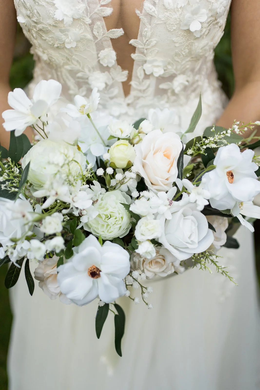 close up of bride holding stunning white, cream with a touch of greenery bride bouquet
