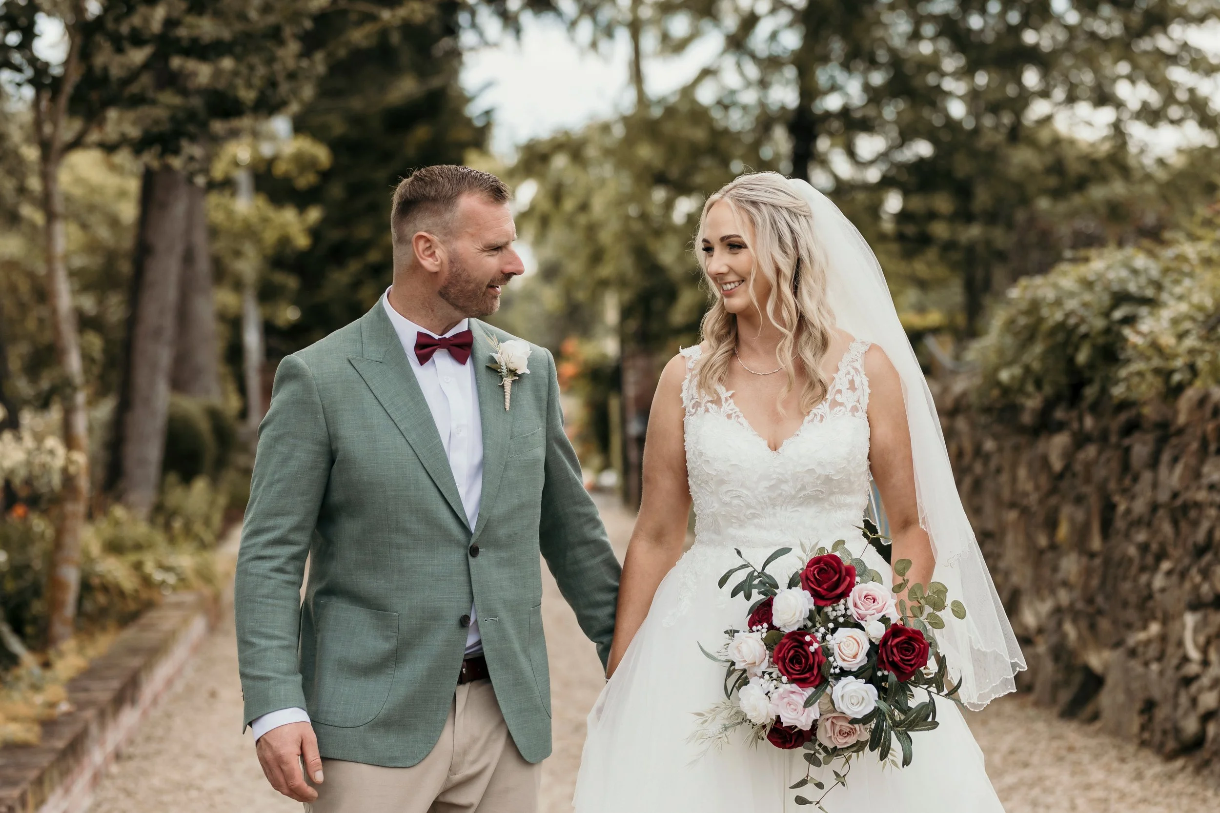 red white and pink bouquet featured during newlywed portraits