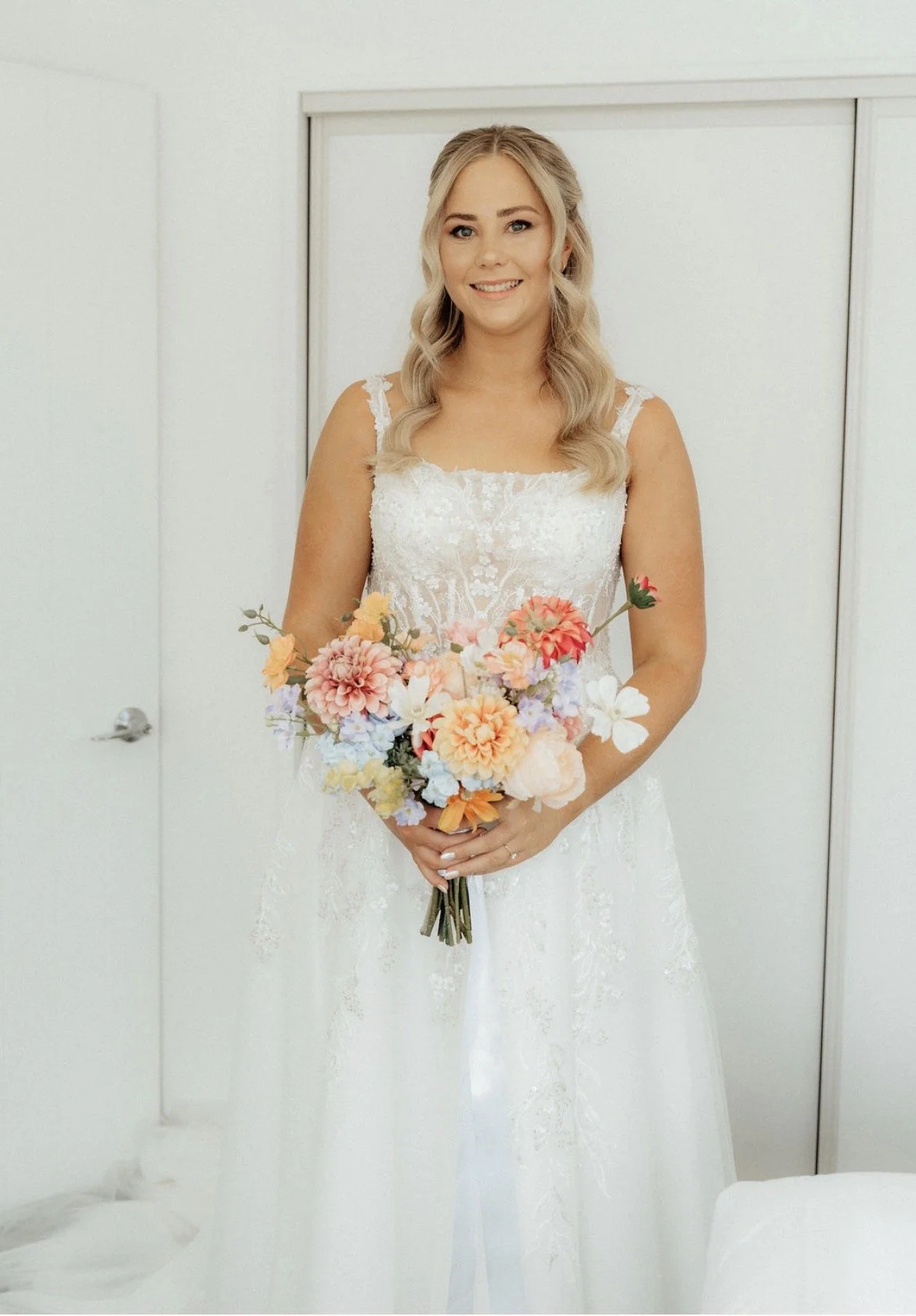 Bride in white room holding her colourful bride bouquet