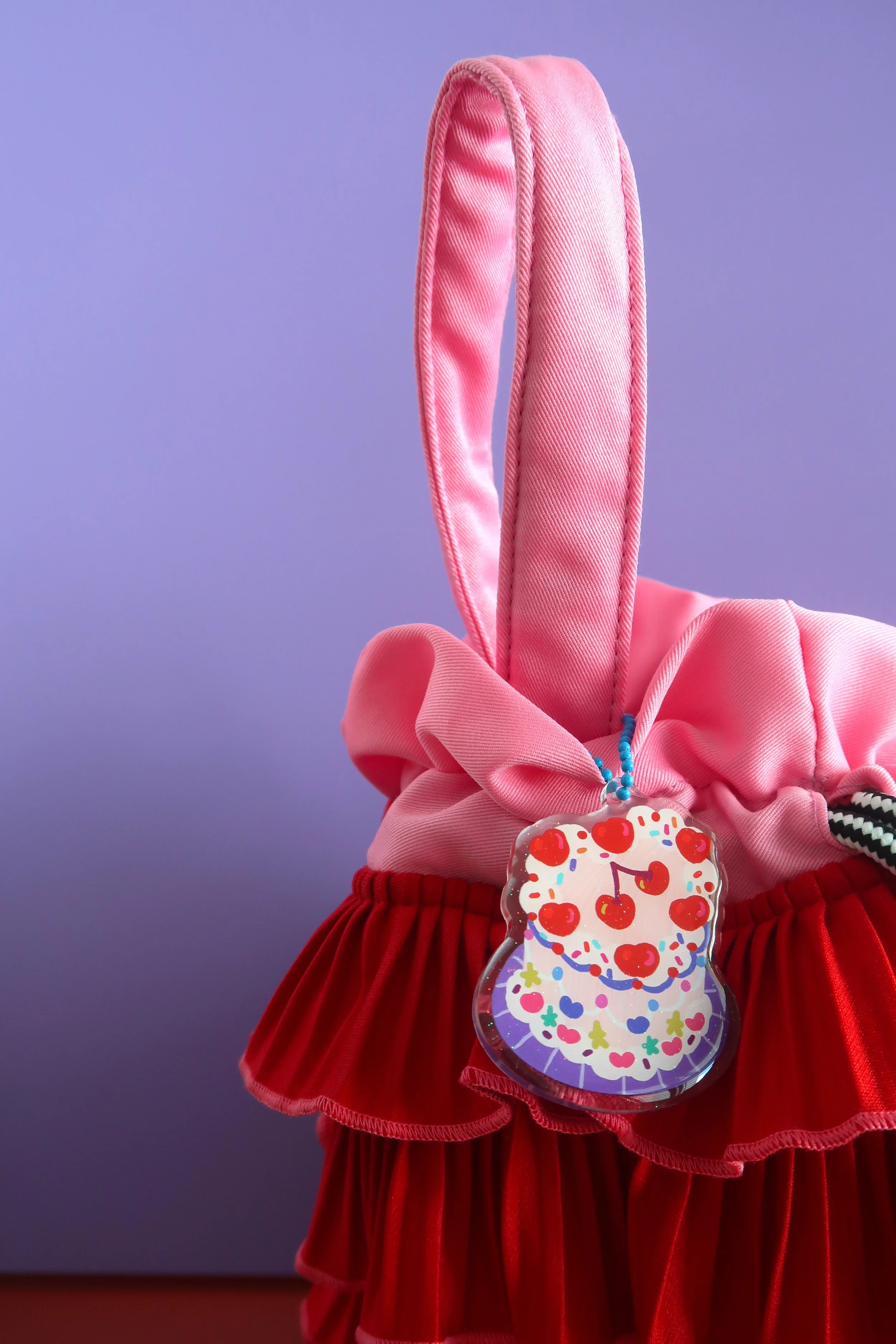 Glitter and rounded acrylic cute cake charm. Approx. 6cm. Suitable for bags, and keychains. Illustrated by Nina Zai in Singapore. The Wrecklessmess.