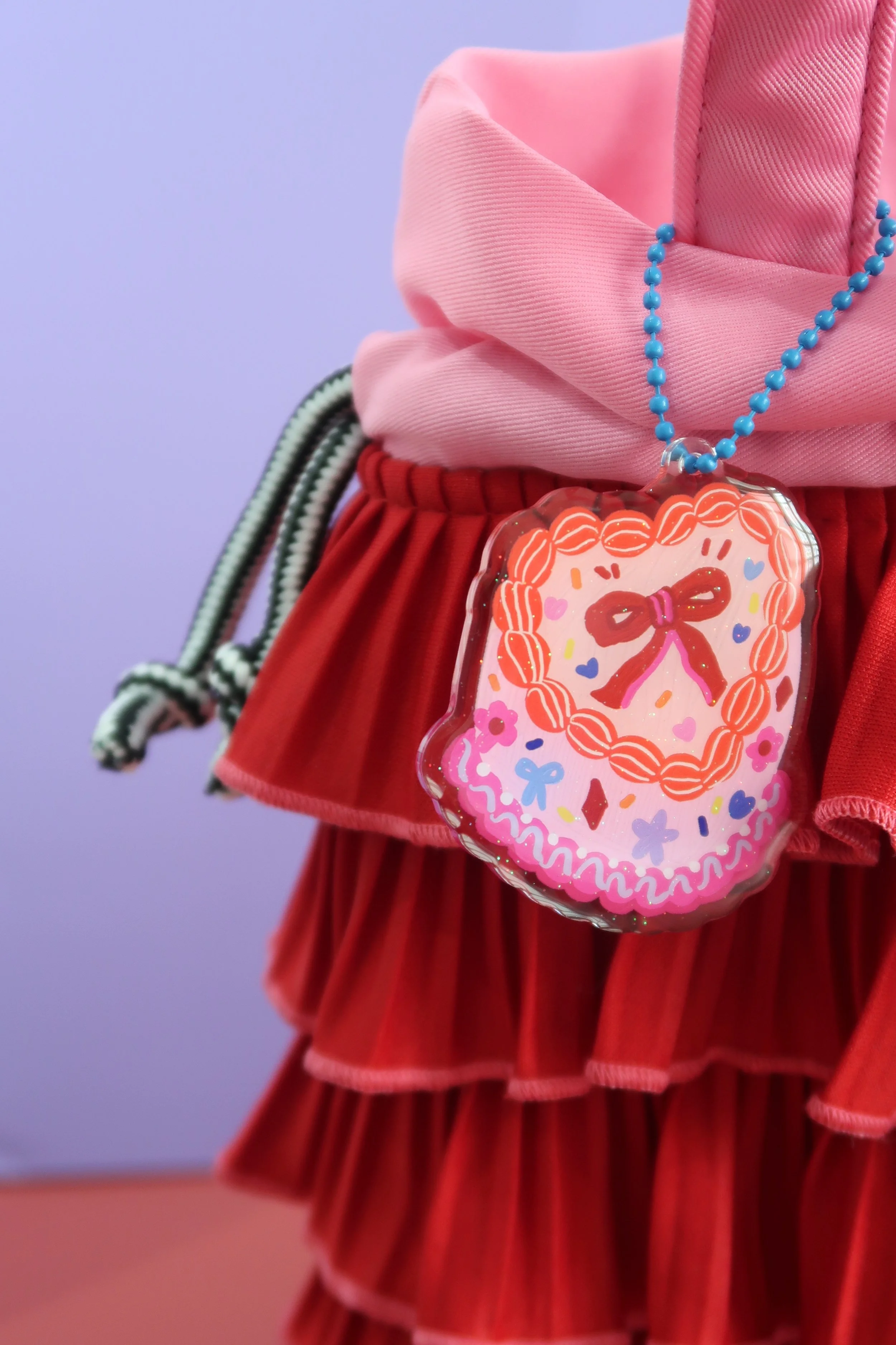 Glitter and rounded acrylic cute cake charm. Approx. 6cm. Suitable for bags, and keychains. Illustrated by Nina Zai in Singapore. The Wrecklessmess.