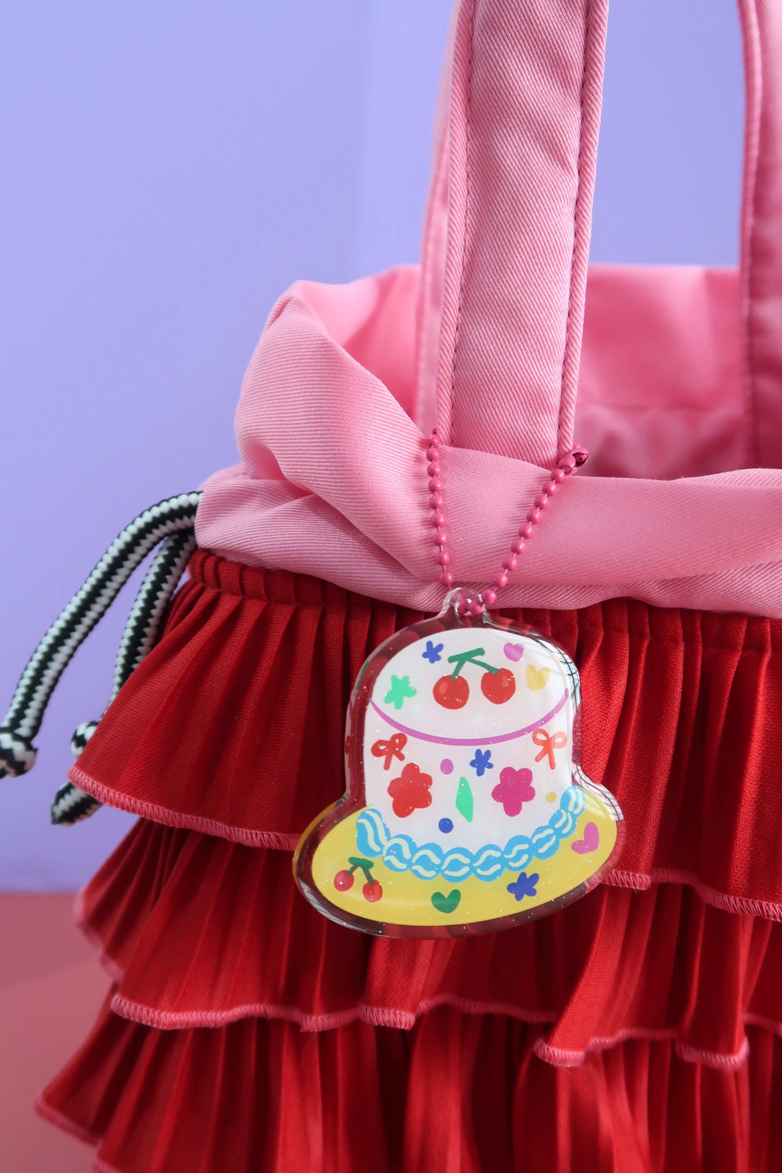 Glitter and rounded acrylic cute cake charm. Approx. 6cm. Suitable for bags, and keychains. Illustrated by Nina Zai in Singapore. The Wrecklessmess.