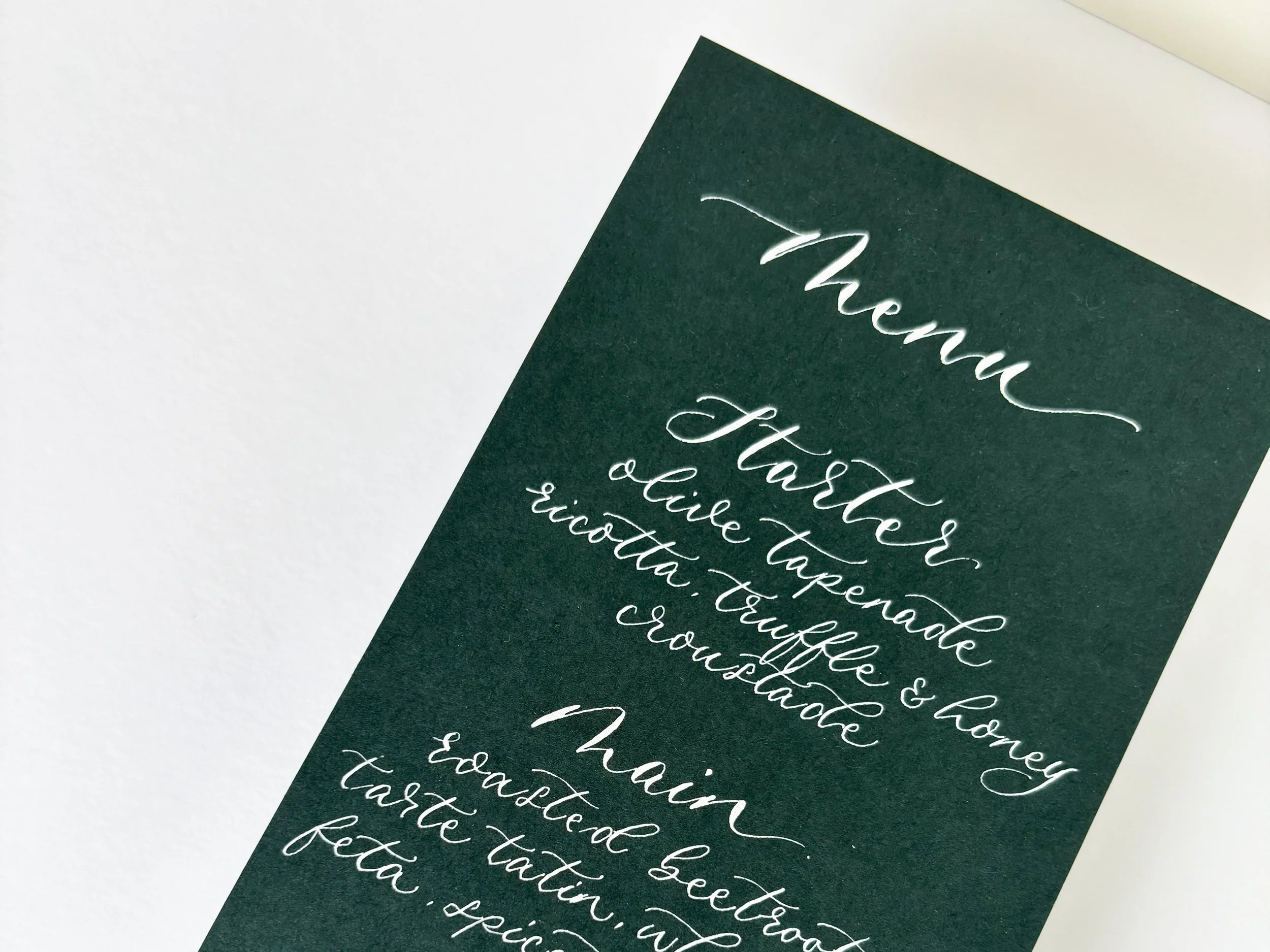Racing Green wedding menu finished with white handwritten modern calligraphy. Luxurious wedding menus