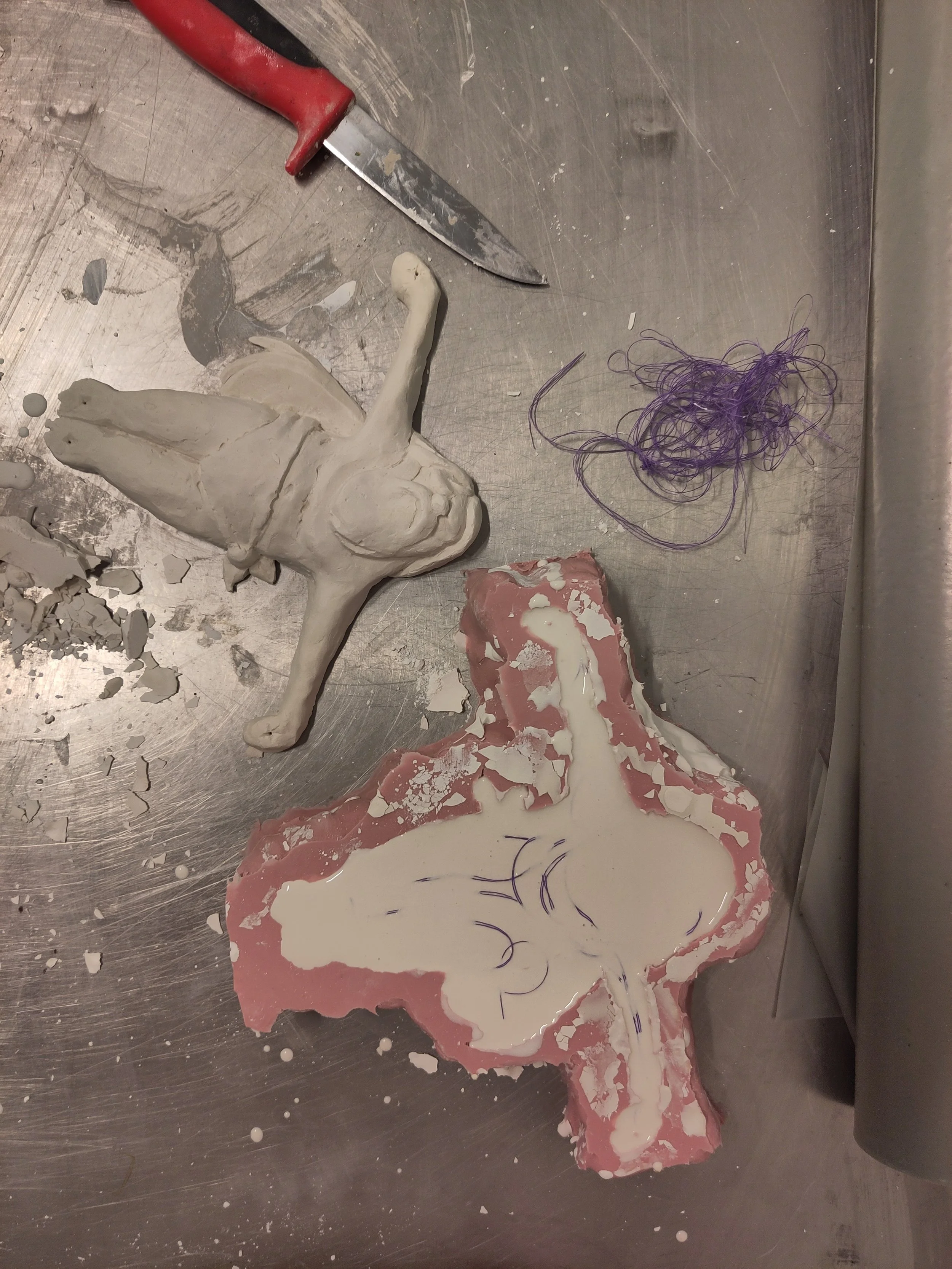 Two Jesi in plaster, one still in the mold, with some thread for reinforcing.