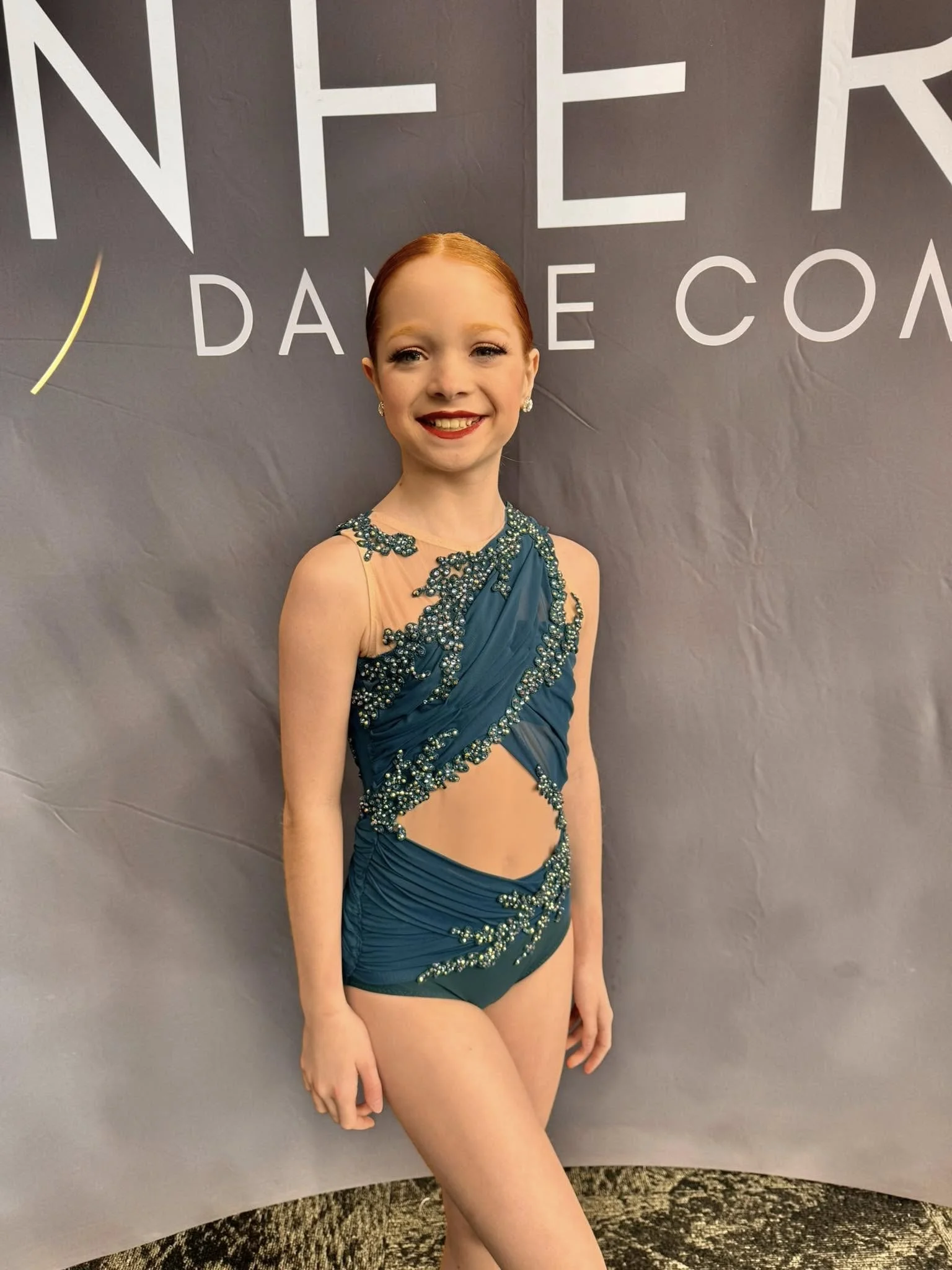 Young dancer wearing custom teal and gold embellished solo costume by Tilly Blue at Inferno Dance Competition