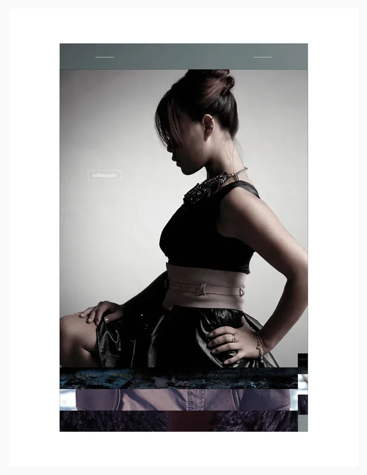 Profile view of a woman with dark hair tied up, wearing a black sleeveless top with embellishments, a high-waisted skirt, and jewelry, sitting with one hand on her waist against a plain background.