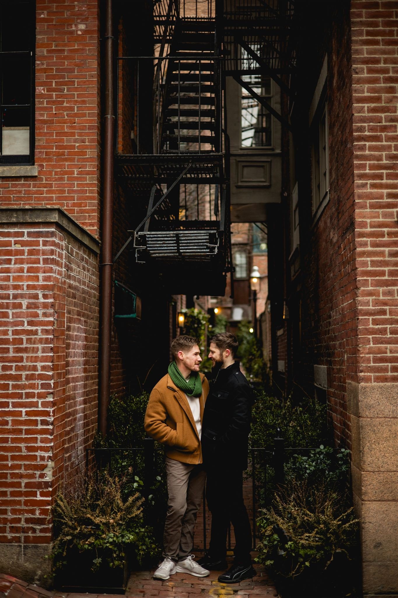 Engaged couple sharing a quiet moment in a brick alleyway in Beacon Hill, Boston