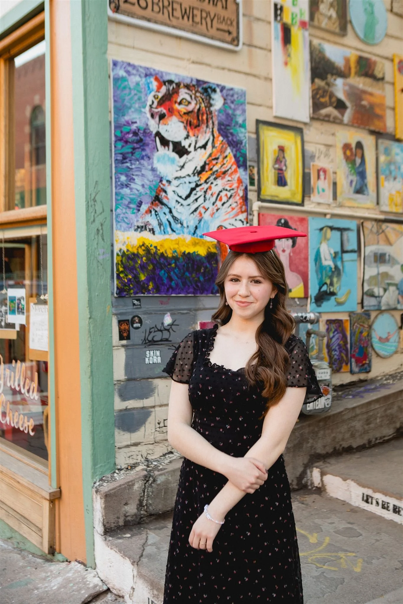 High school senior standing in front of colorful street art during an urban senior photo session in the Boston area.