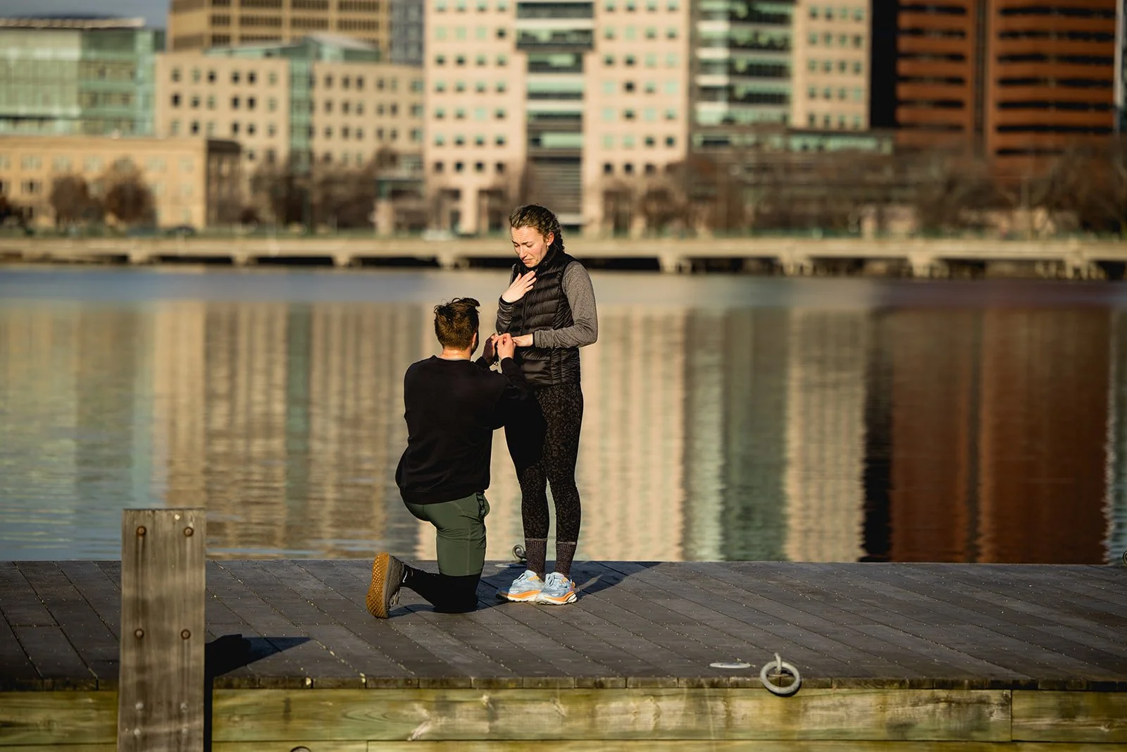 Surprise proposal on the dock at the Charles River Esplanade with the Boston skyline reflected on the water.