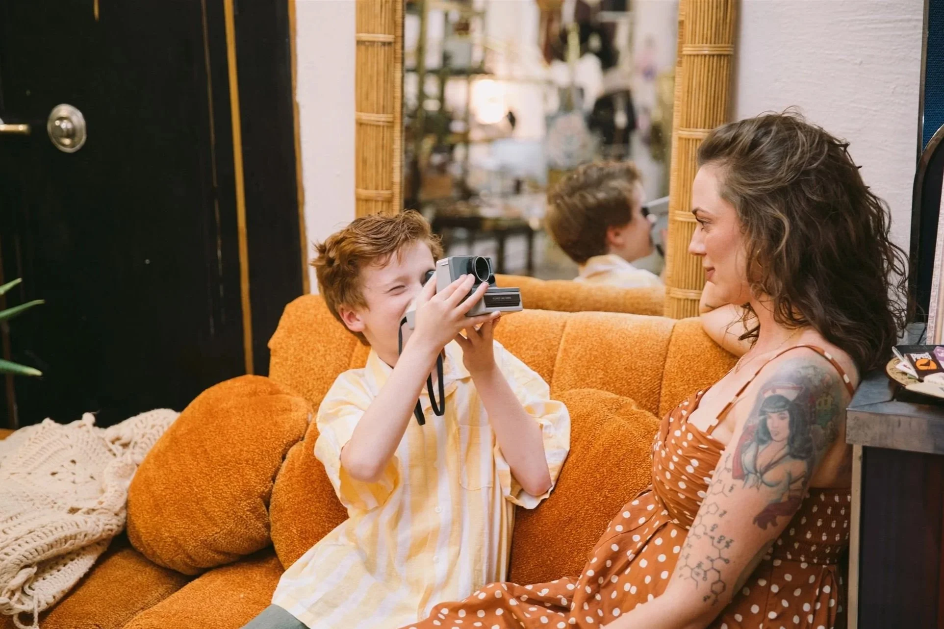 Mother and son candidly posing for a photo while sitting on a couch in a vintage shop located in Bisbee, Arizona