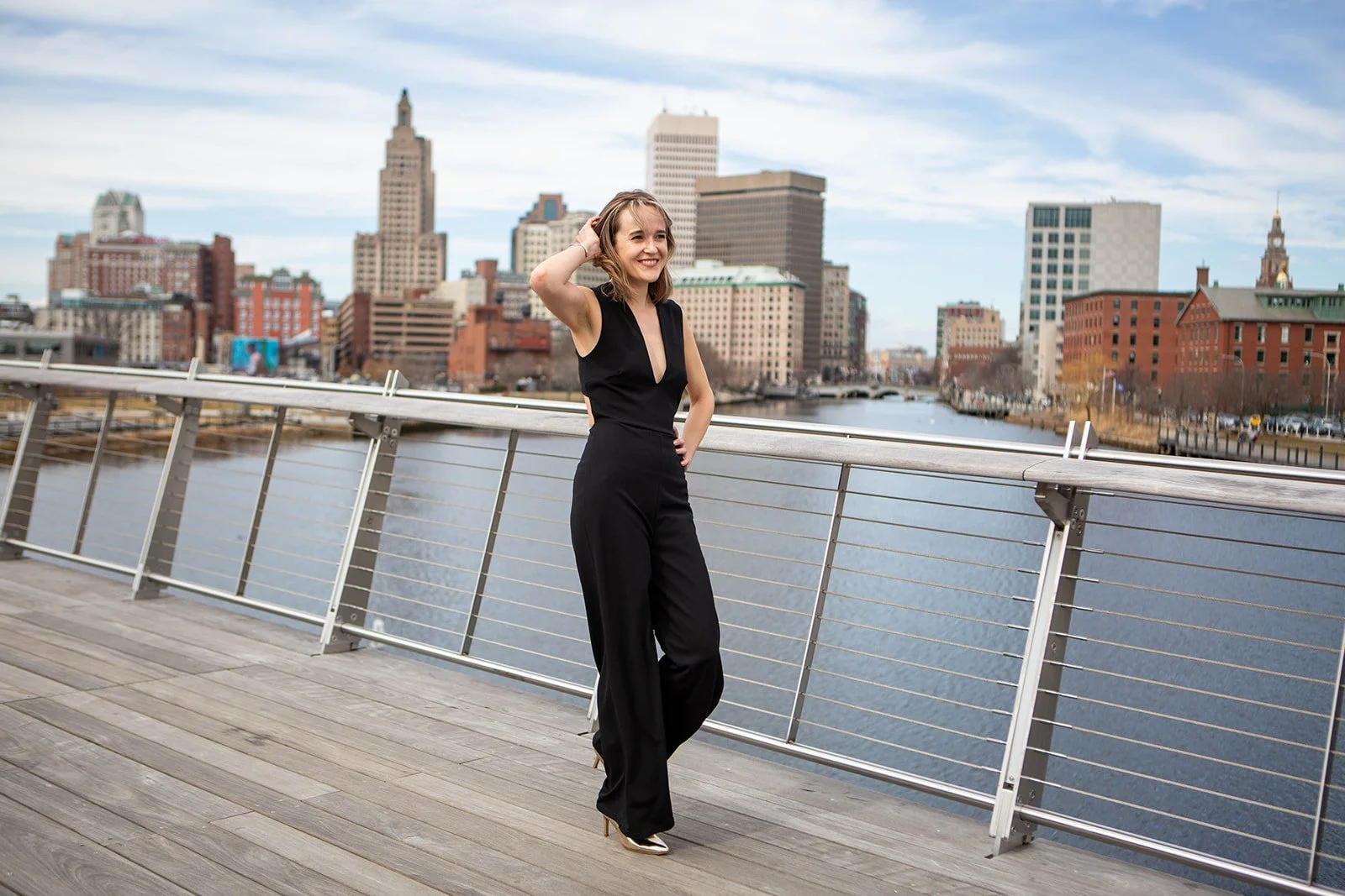 Woman walking across the Providence Pedestrian Bridge in a natural dating profile photo session.