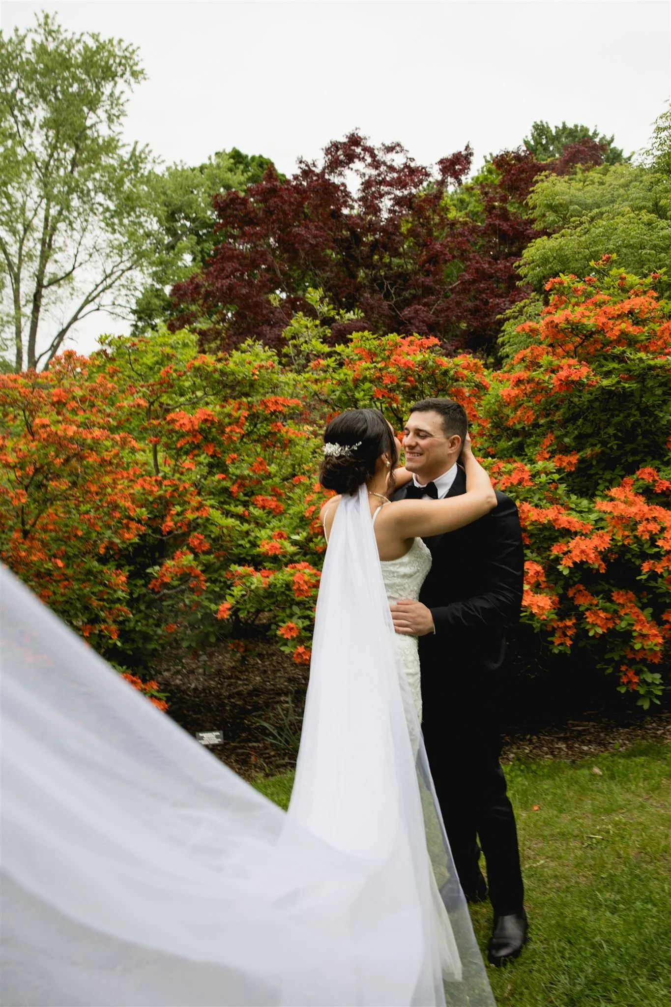 bride and groom smiling and embracing each other at Arnold's  Arboretum in Jamaica Plain Boston