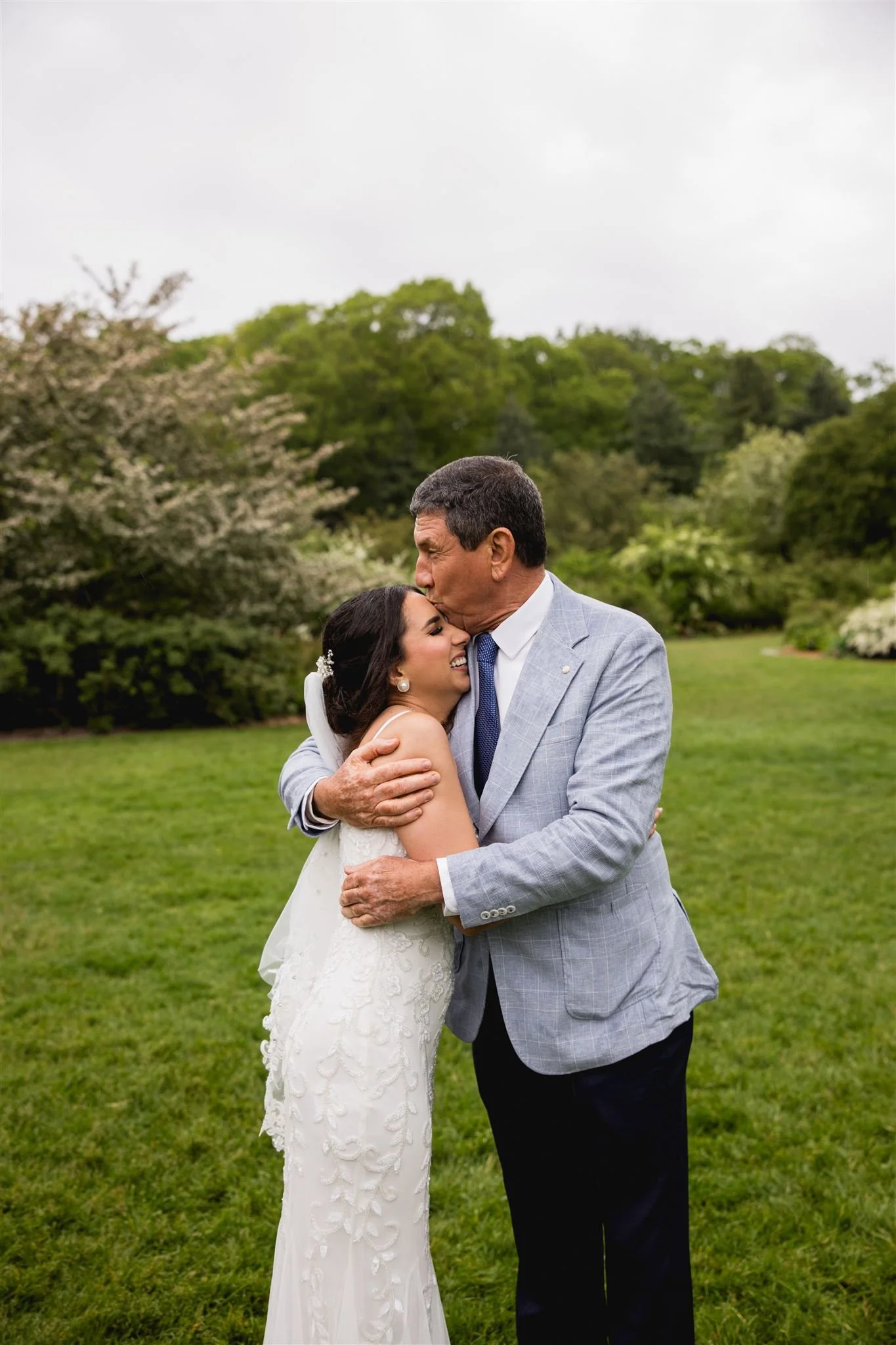 bride and her father sharing a candid loving embrace at micro wedding in Arnold's Arboretum in Jamaica Plains Boston