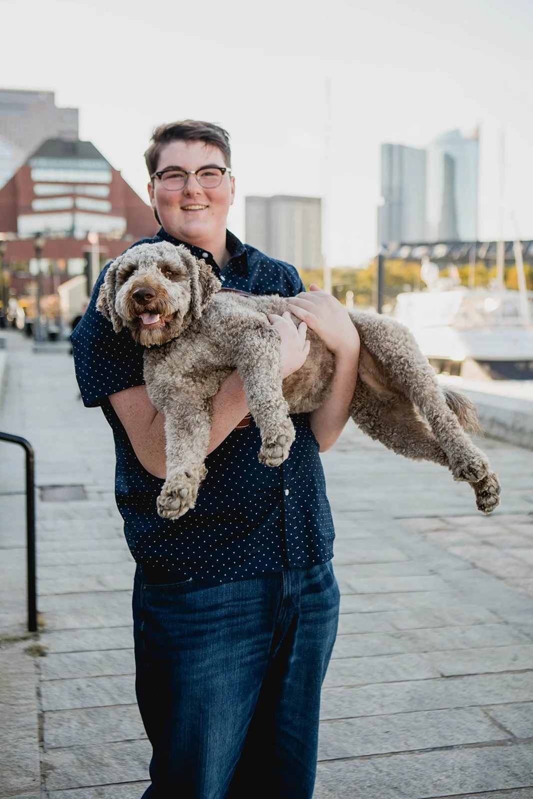High school senior holding their dog during a waterfront senior photo session in the Boston area.