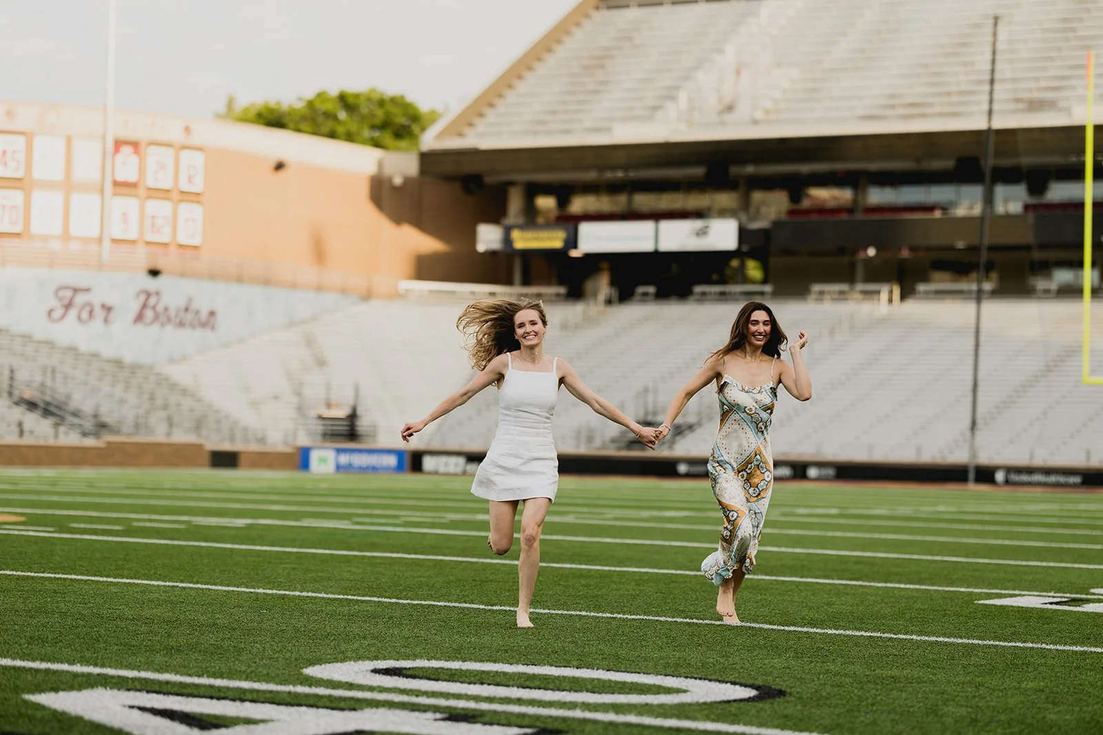 Boston College graduate students running through the football stadium field