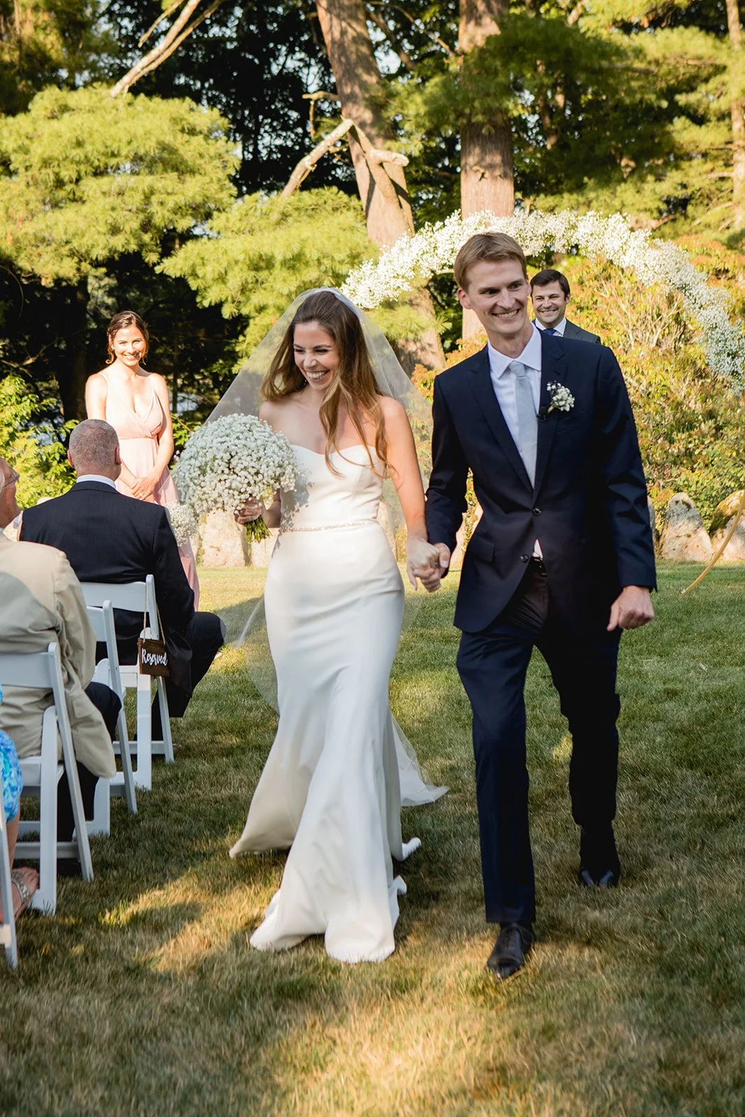 Newly married couple walking back up the aisle after ceremony at Estate at Moraine Farm wedding in Beverly, Massachusetts