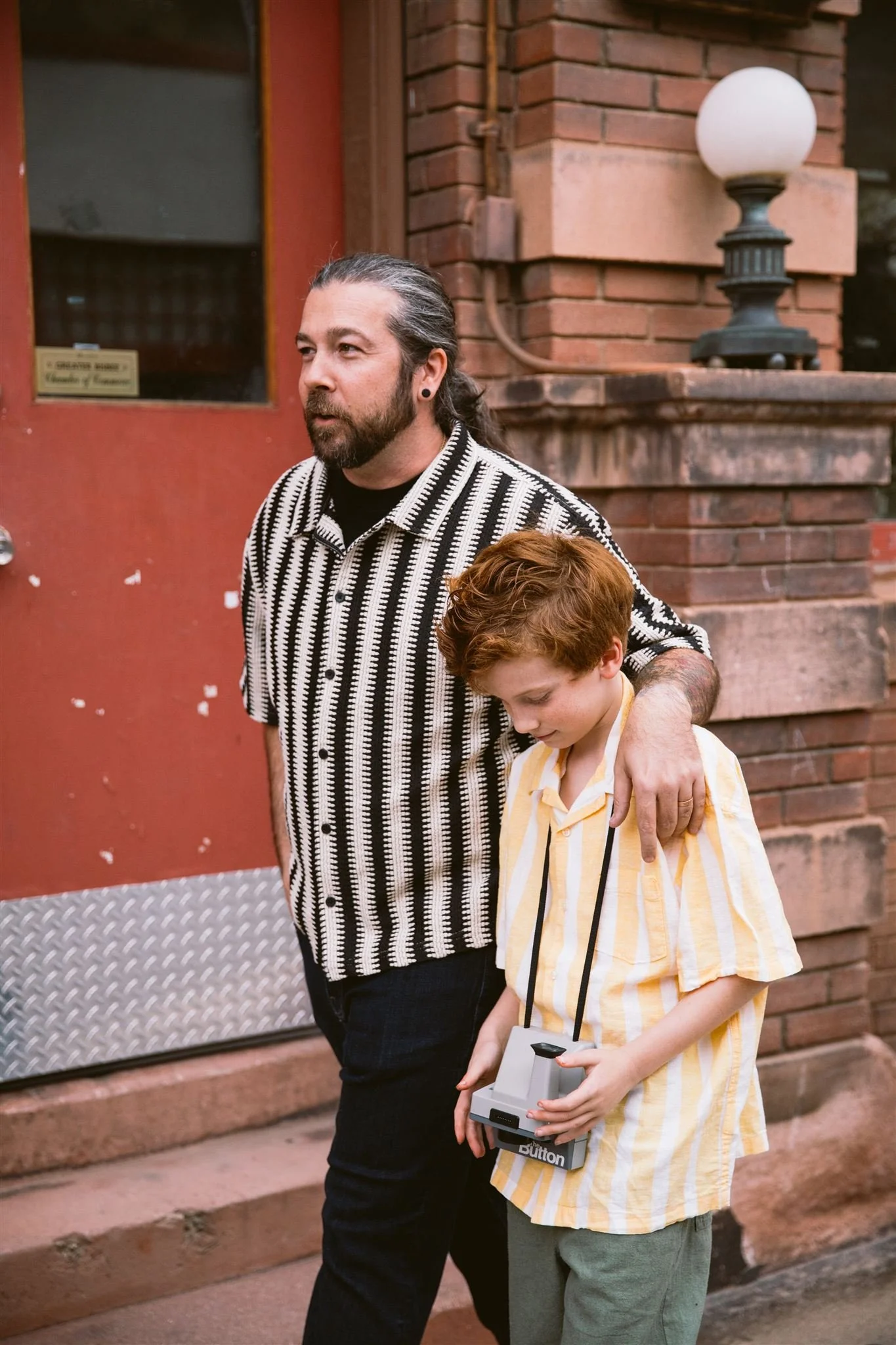 Father and son walking candidly on a quiet historic street of downtown Bisbee, Arizona