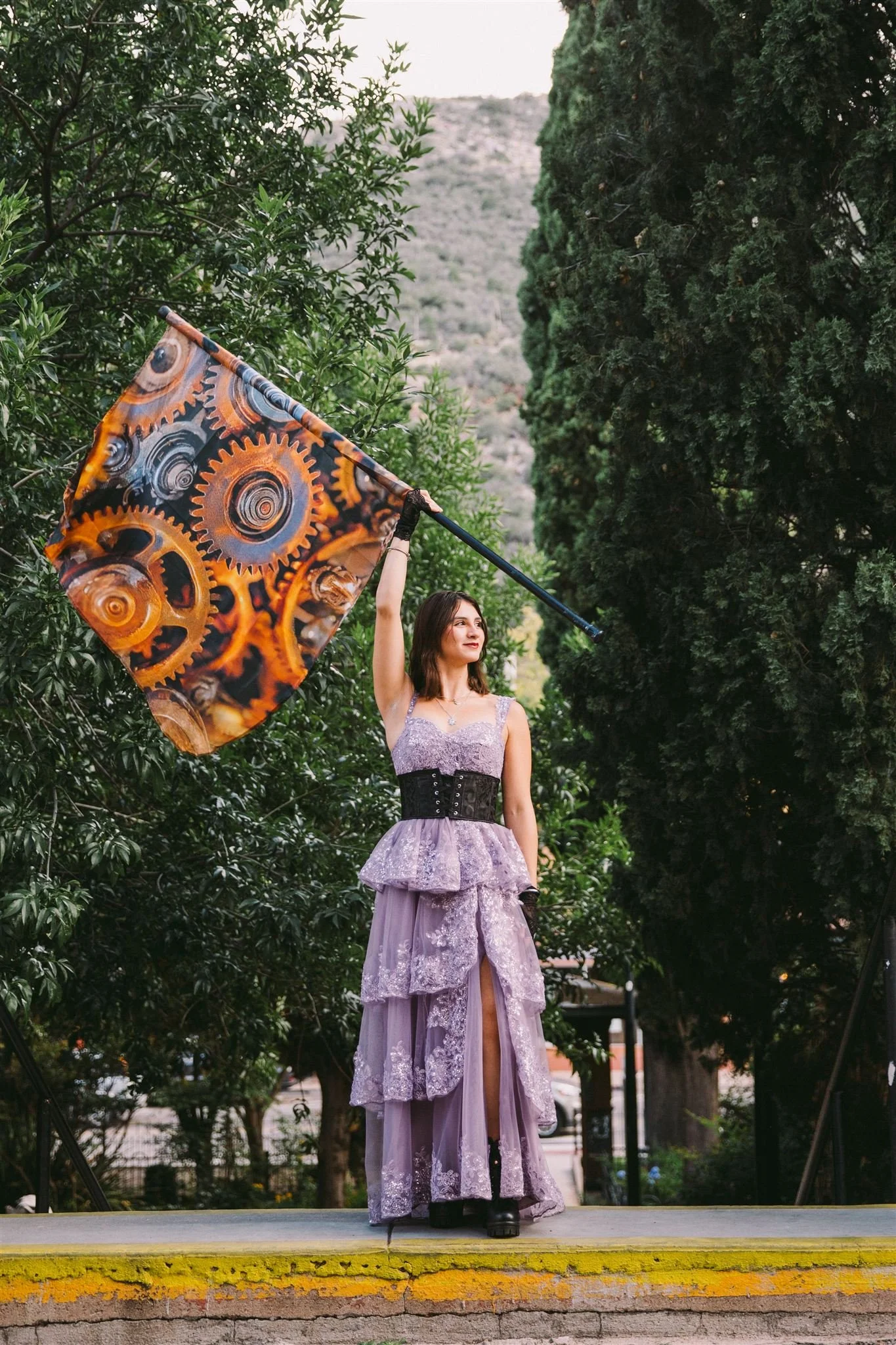 High school senior holding a patterned flag in a park during a creative outdoor senior photo session in the Boston area.